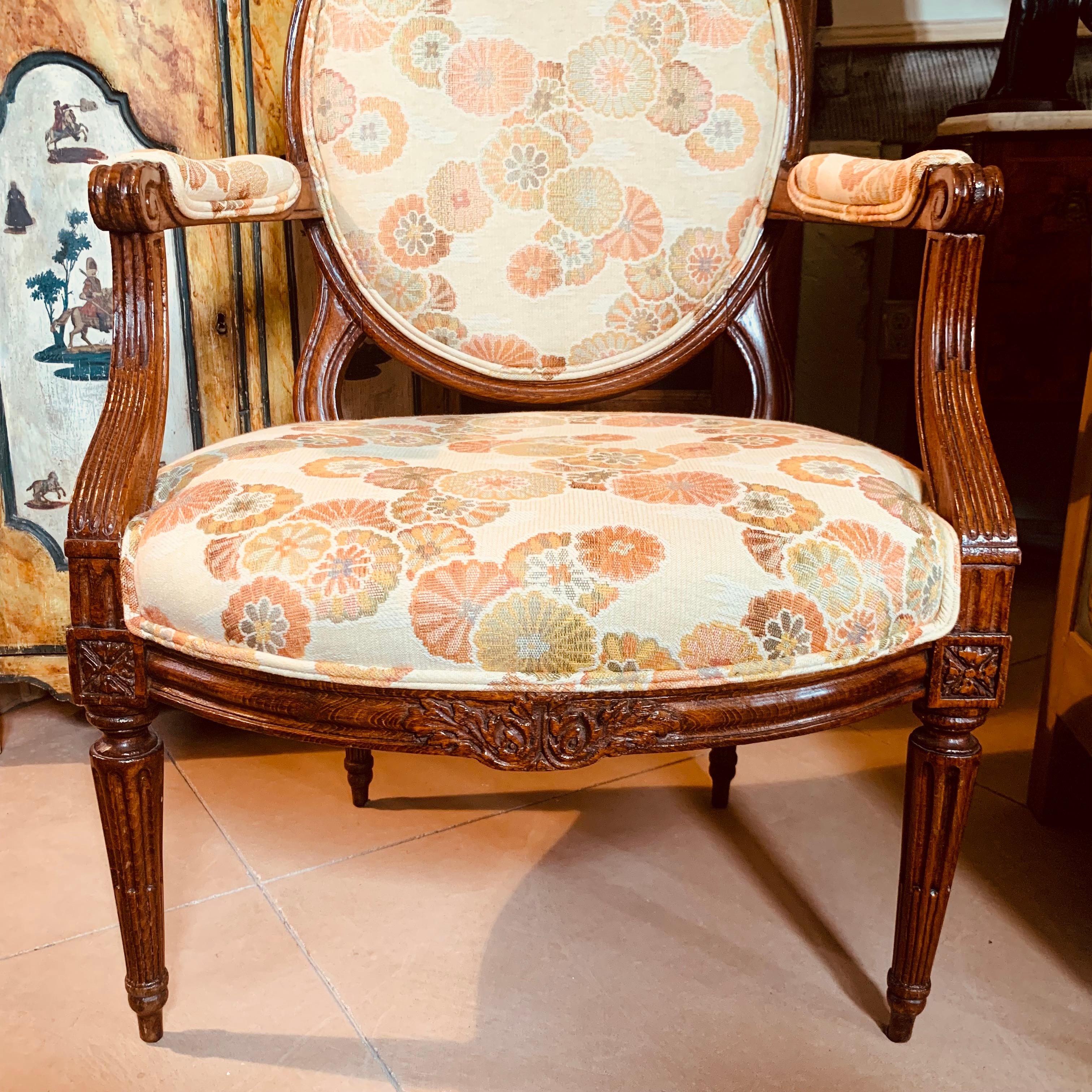 A set of four antique armchairs, handsomely carved with an acanthus flourish at the crests and at the centers of each front seat rail, the arms and turned tapered legs attractively carved with stop fluting. Seat bottoms reinforced with recent corner