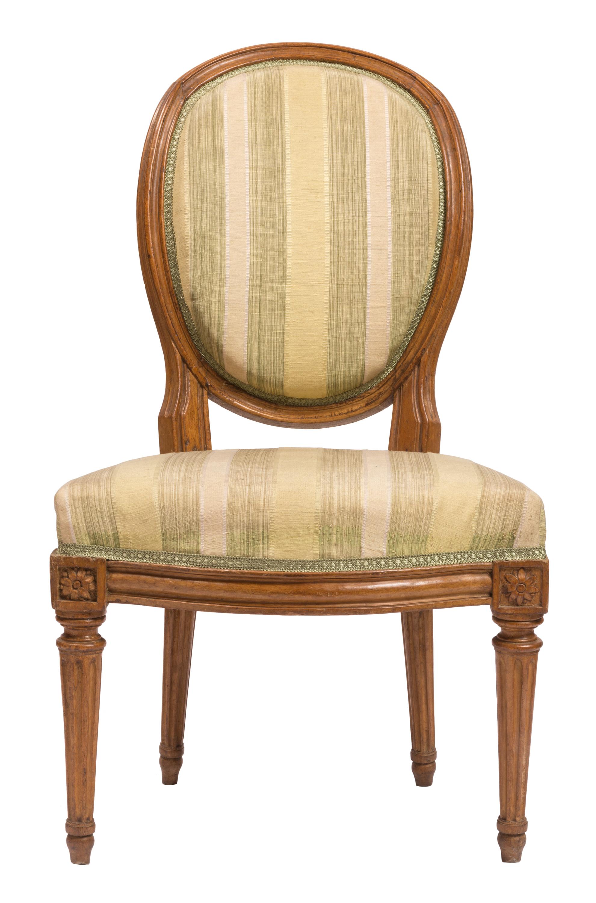 A matched set of 19th century Louis XVI style dining or side chairs with walnut furniture, nicely carved floral rosettes, and new cream and light green striped silk upholstery. A Classic chair silhouette with its rounded, framed seat back, combined