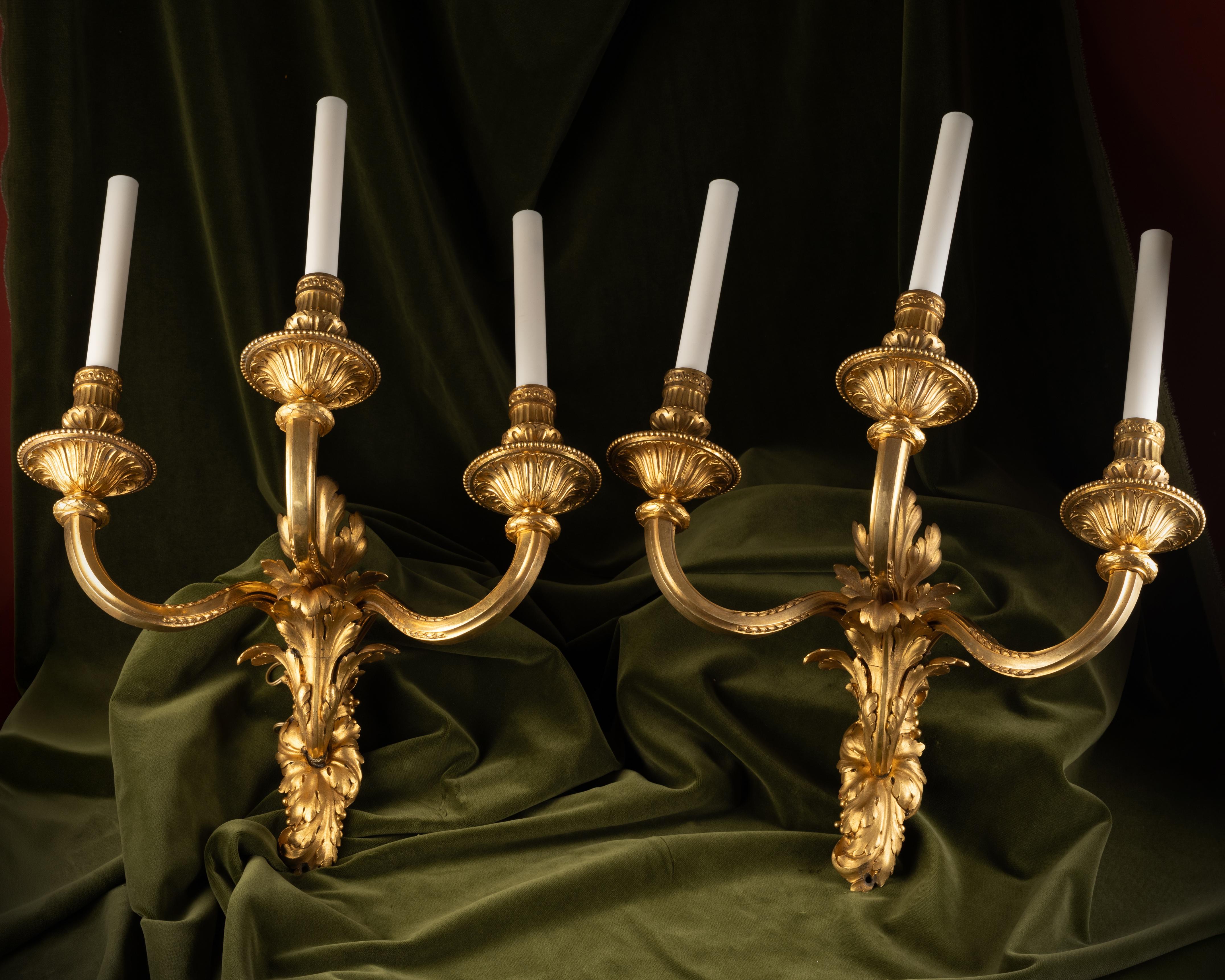 Conjunto de cuatro apliques de pared de tres luces en bronce dorado.
Bronce dorado.
Francia.
30 x 35 x 40 cm (11.8 x 13.8 x 15.7 in).

El diseño de este conjunto parece inspirarse en formas ampliamente difundidas por el ornamentista Charles