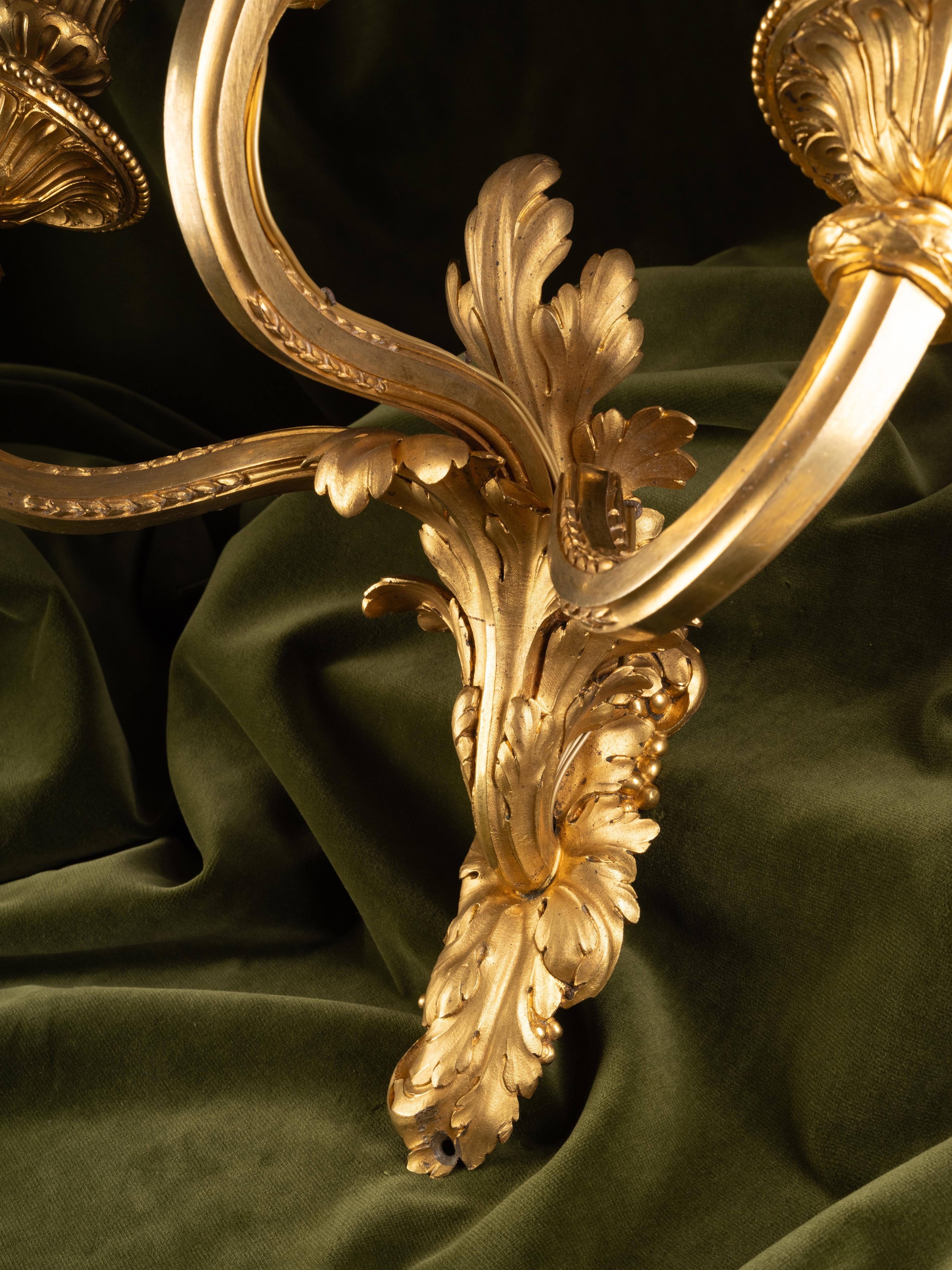 Juego de cuatro apliques de pared de tres luces, estilo Luis XVI, en bronce dorado Dorado en venta