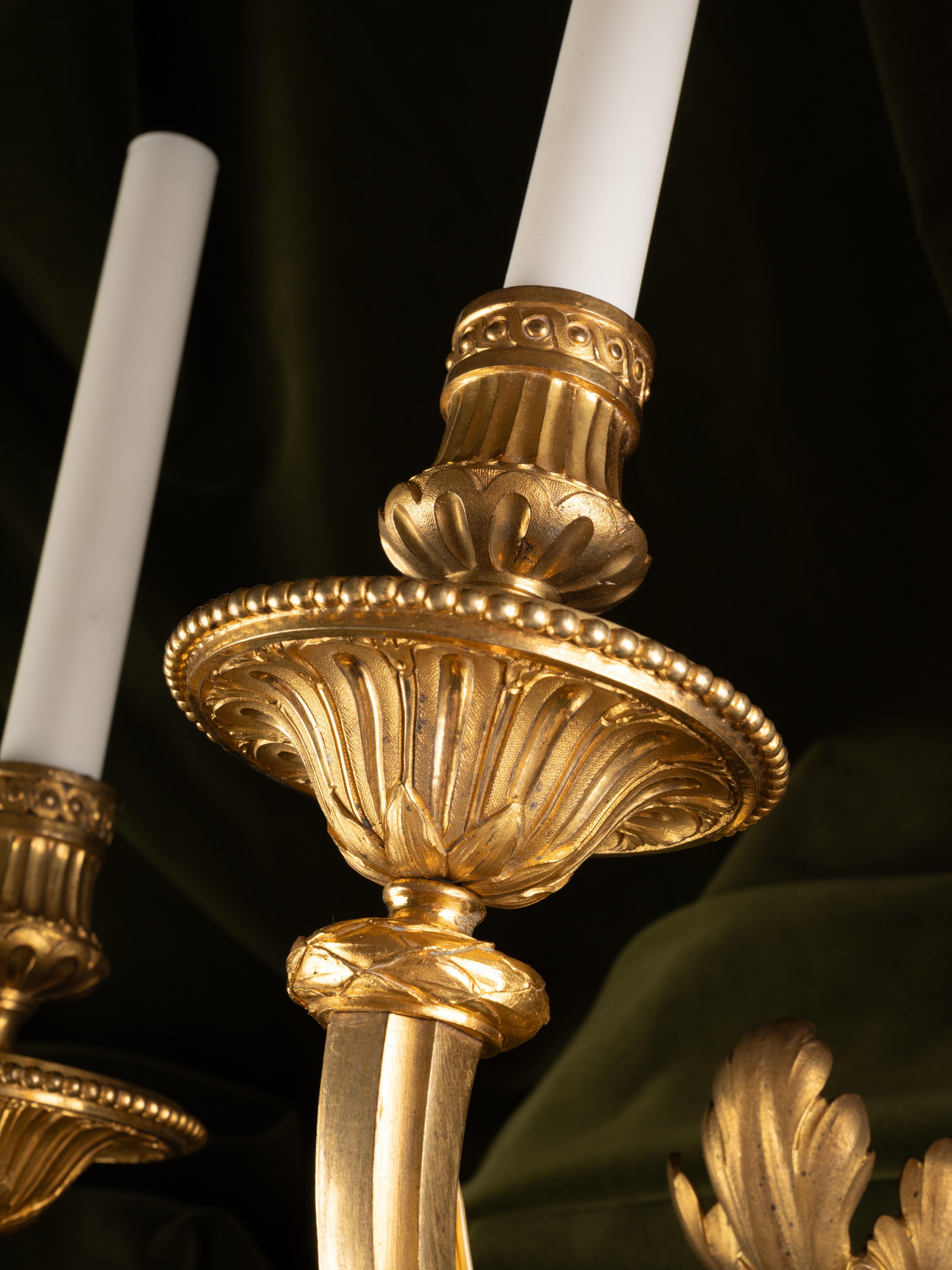 Juego de cuatro apliques de pared de tres luces, estilo Luis XVI, en bronce dorado en Bueno estado para la venta en PARIS, FR