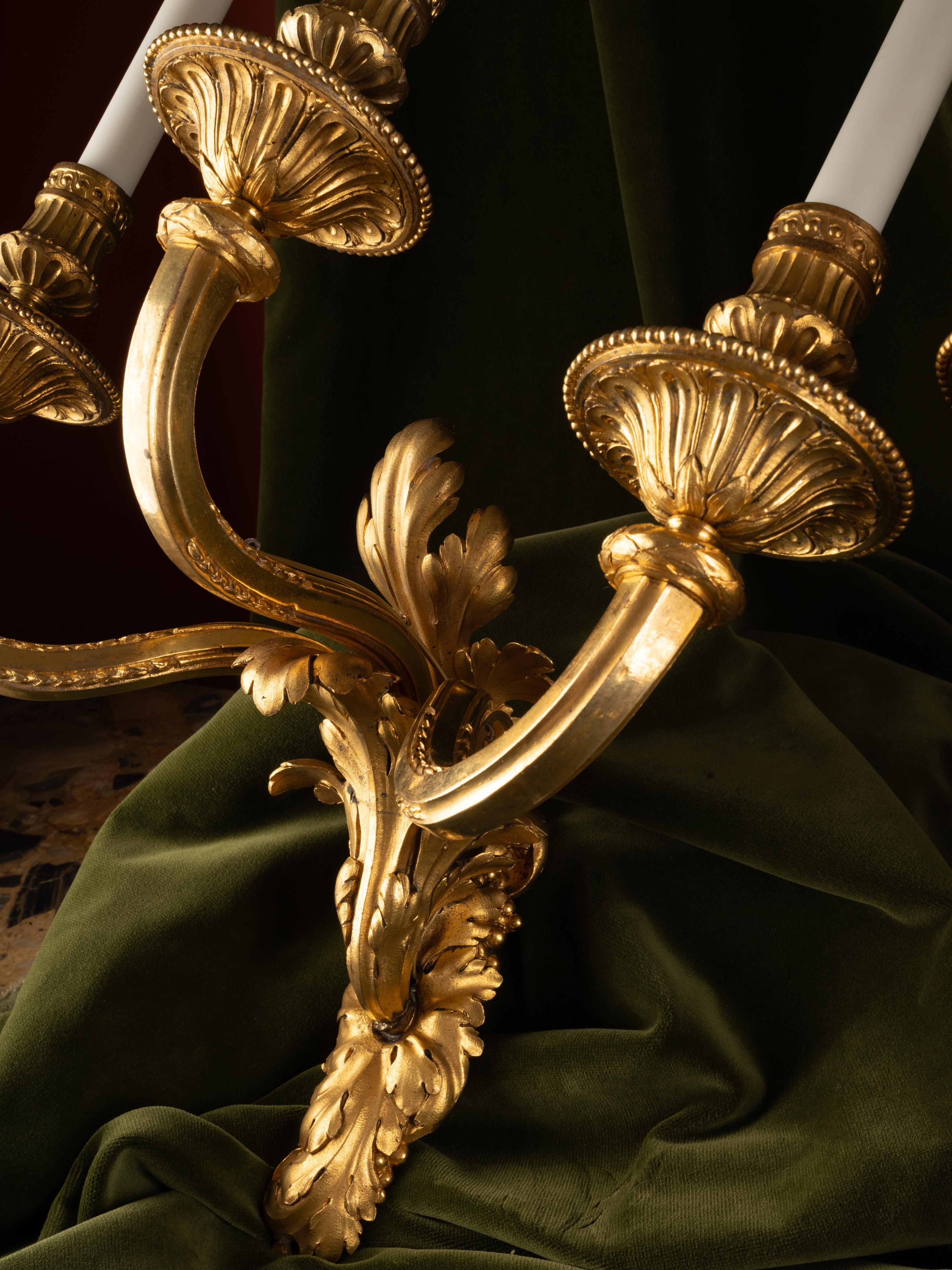 Juego de cuatro apliques de pared de tres luces, estilo Luis XVI, en bronce dorado siglo XIX en venta