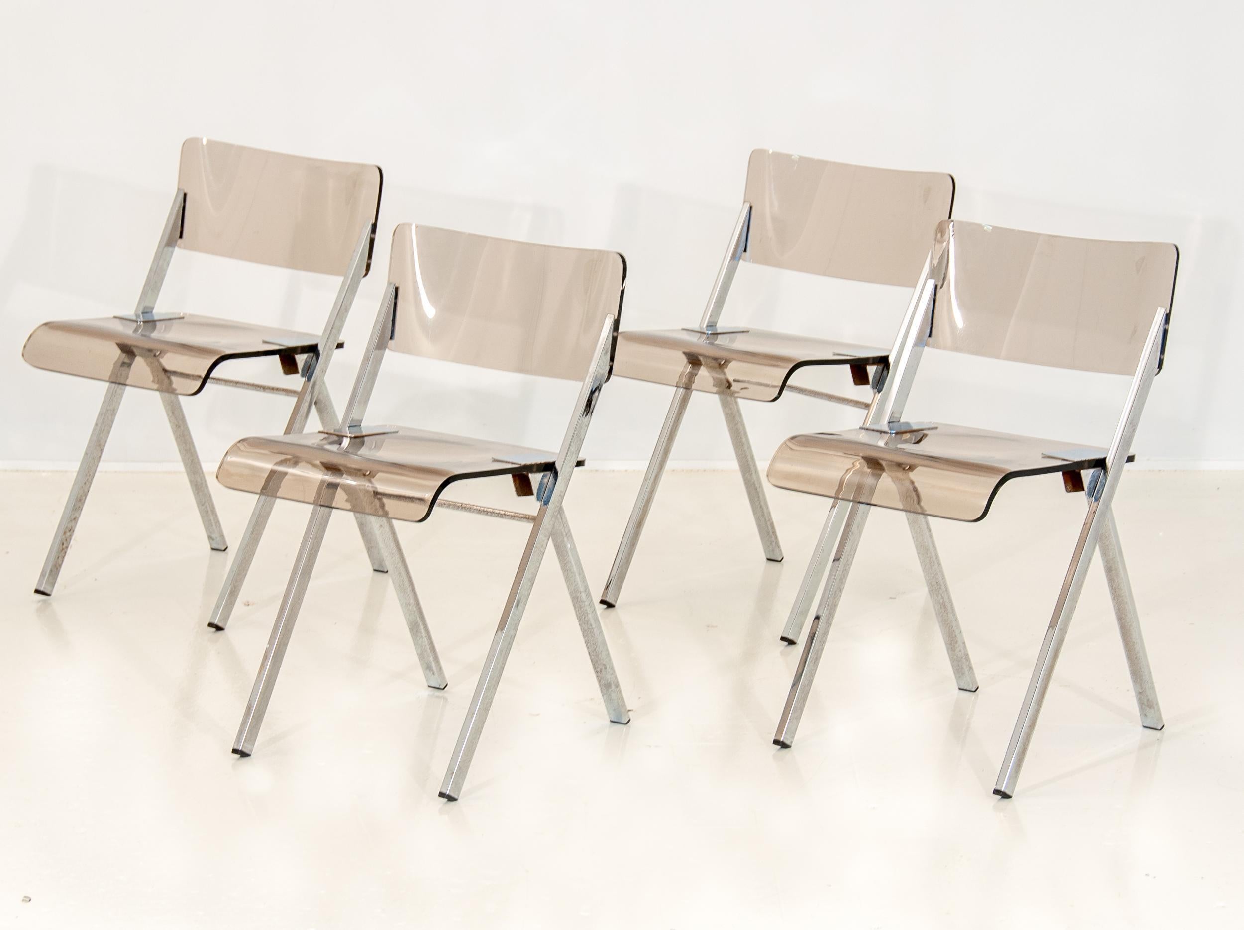 A beautiful set of midcentury folding Lucite chairs. A brilliant and thick pale Smokey Lucite seat and curved back with chrome legs and hinges. Midcentury Italian Lucite in good condition with minor scuffs. Wear consistent with age and use.
