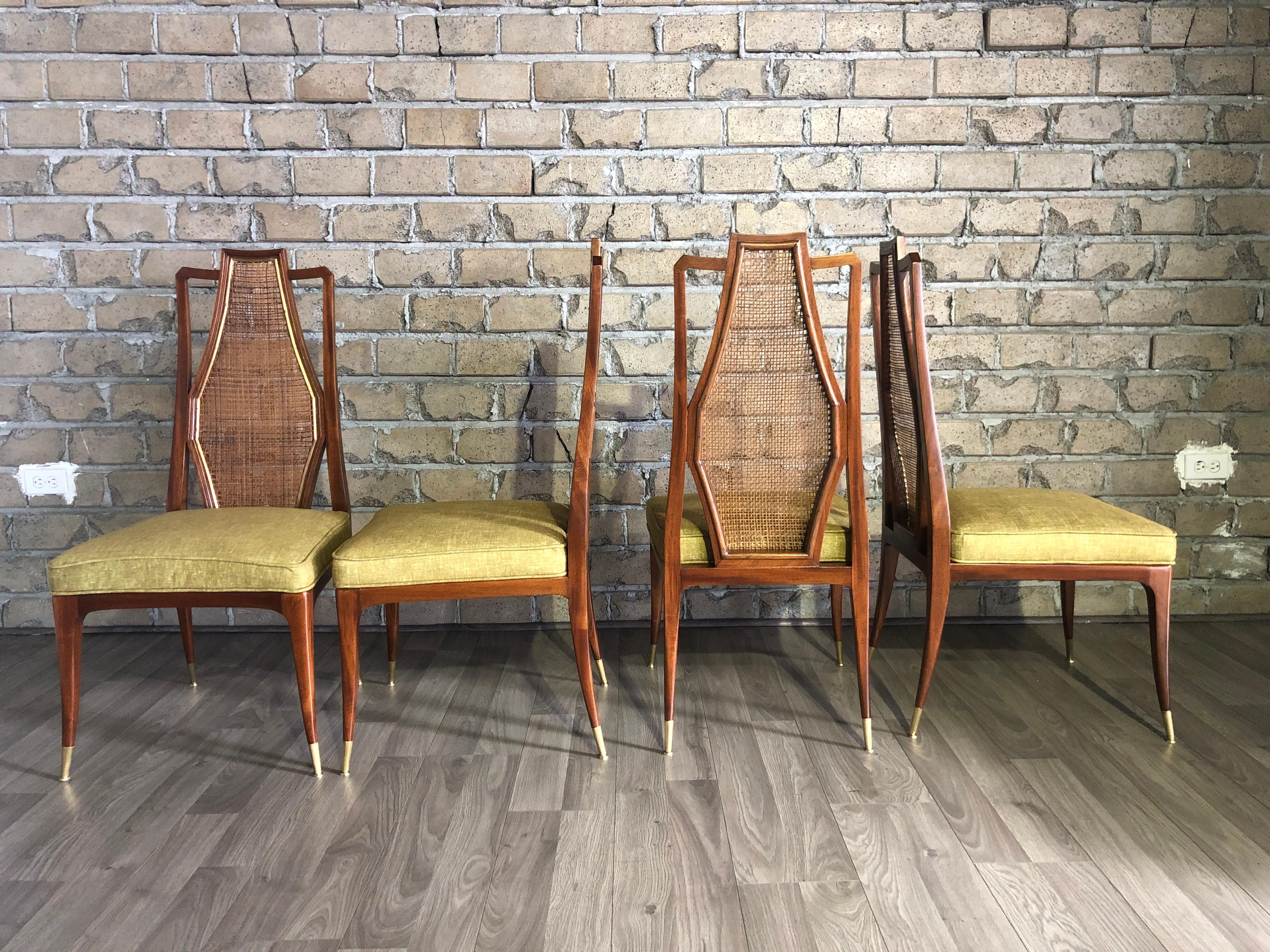 Four vintage Mid-Century Modern dining chairs. The chairs are from the late 1950s, the design is in all its components, the architectural profile backrest with its original cane and outlined in front of a brass strip, the curved front seat makes it
