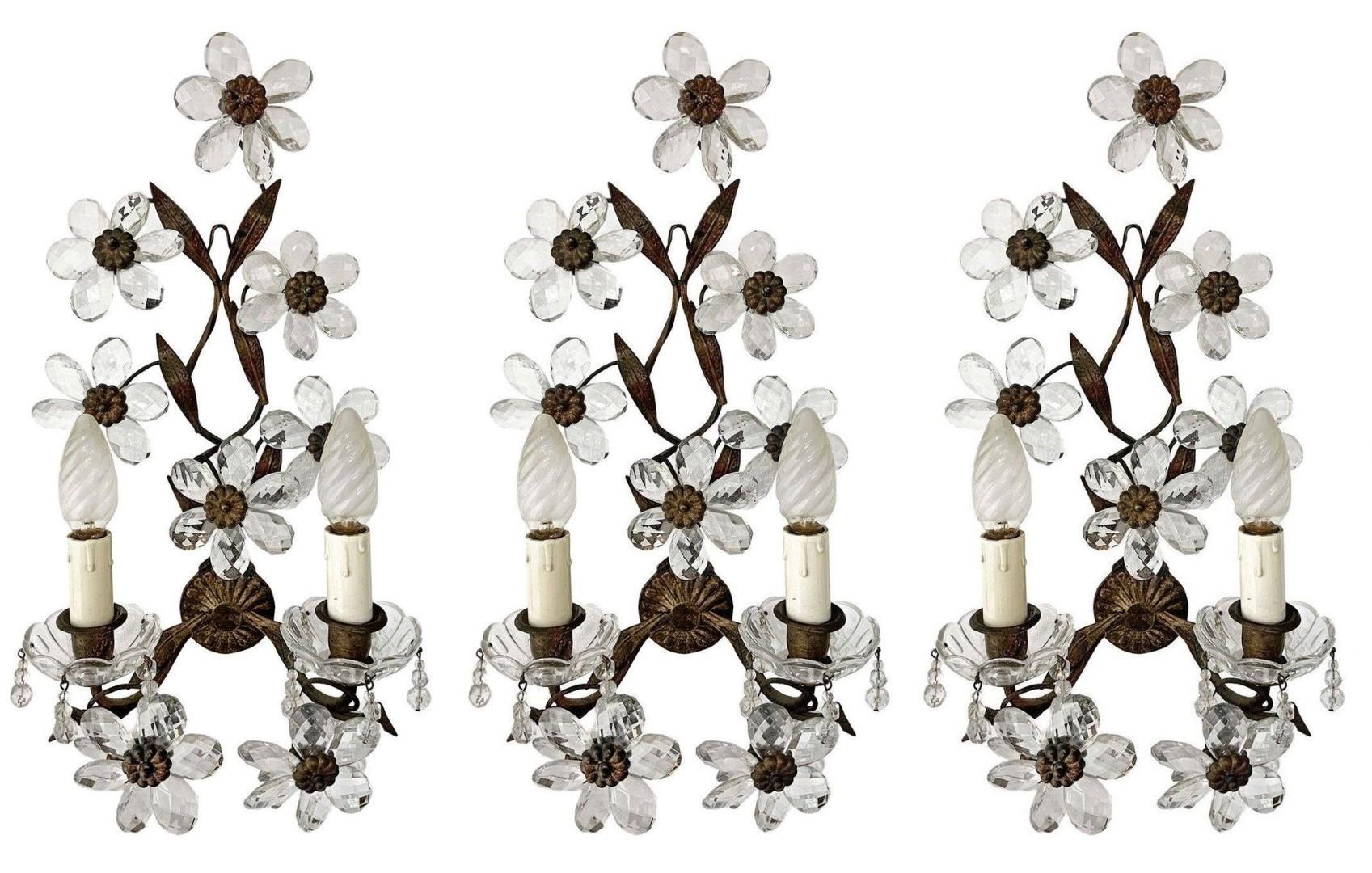 Set of four Maison Bagès gilded wrought iron two-arm wall lights, France, 1920s. Wonderful art environment handcrafted in wrought iron and gilded, enriched with ten clear faceted crystal flowers (each sconce). All four pieces In very good condition,