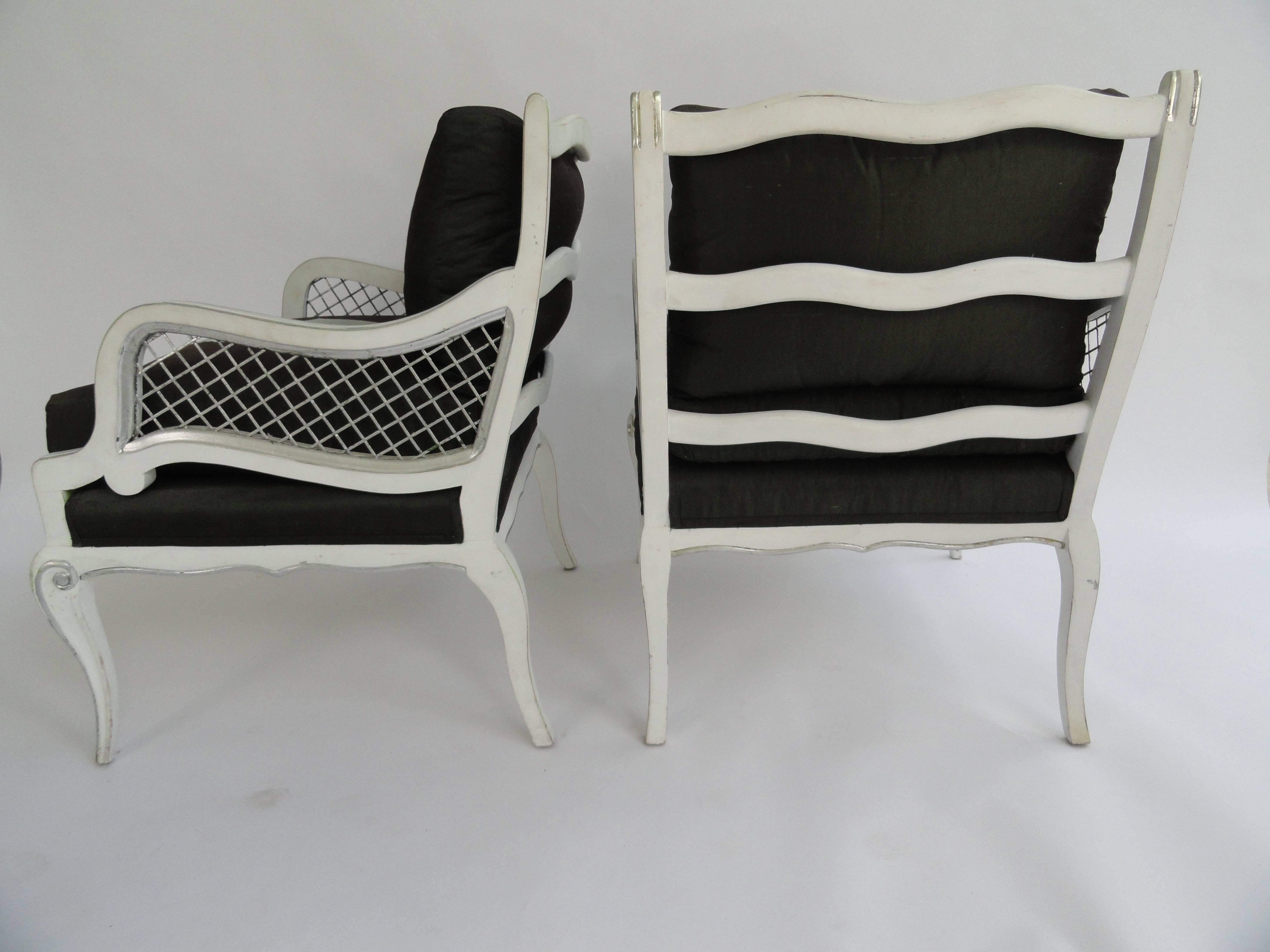Set of four Maison Jansen armchairs with ladder back and metal accent arms. Loose bottom and back cushion of Henry Calvin Athena Taffeta with leather detail. Art Deco chairs are painted white with a silver leaf accent.