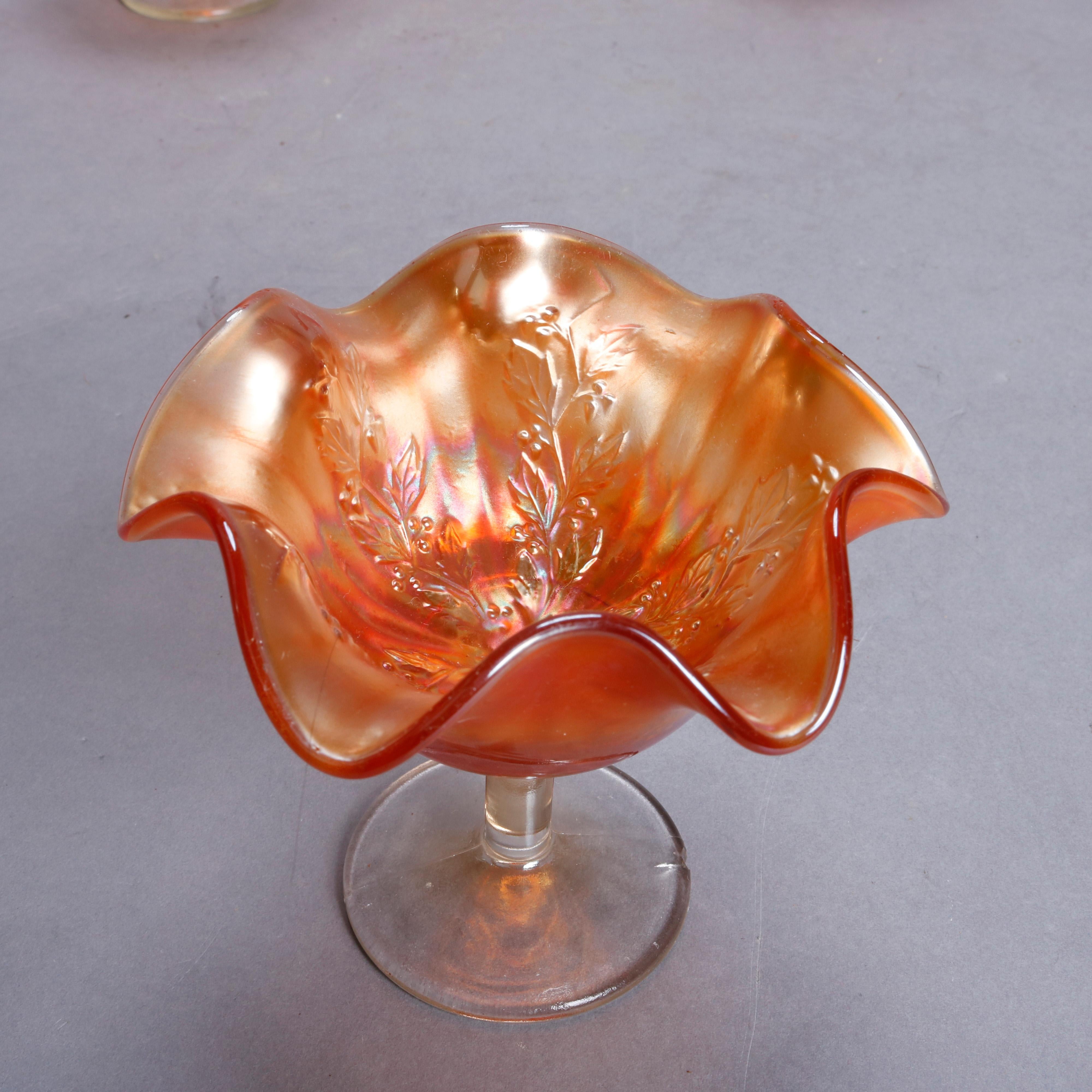 A set of four antique ice cream dessert cups by Fenton offer flared marigold carnival glass in Holly Berry pattern with bowls having ruffled rims and embossed design, raised on clear footed stems, circa 1930

Measures - 4.25