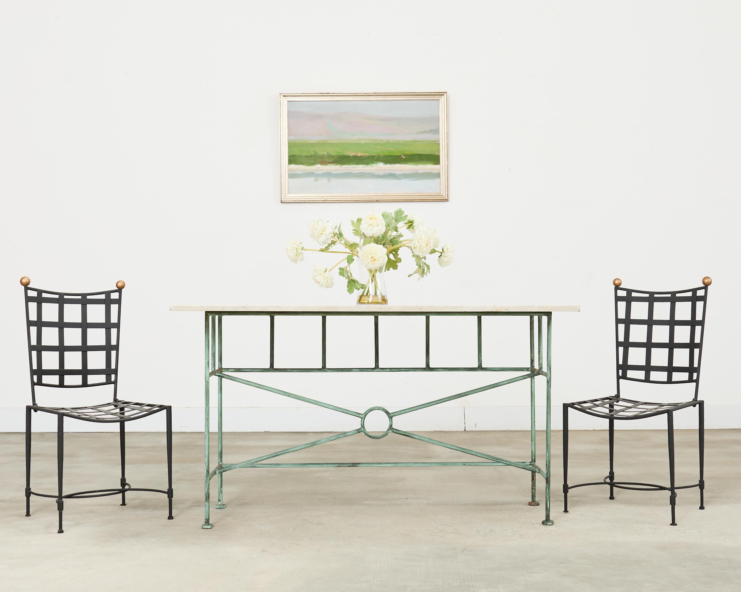 Iconico set di quattro sedie da giardino e da patio in ferro battuto disegnate da Mario Papperzini per John Salterini. Il design moderno di metà secolo è caratterizzato da schienali e sedute a reticolo geometrico di gusto neoclassico. Gli schienali