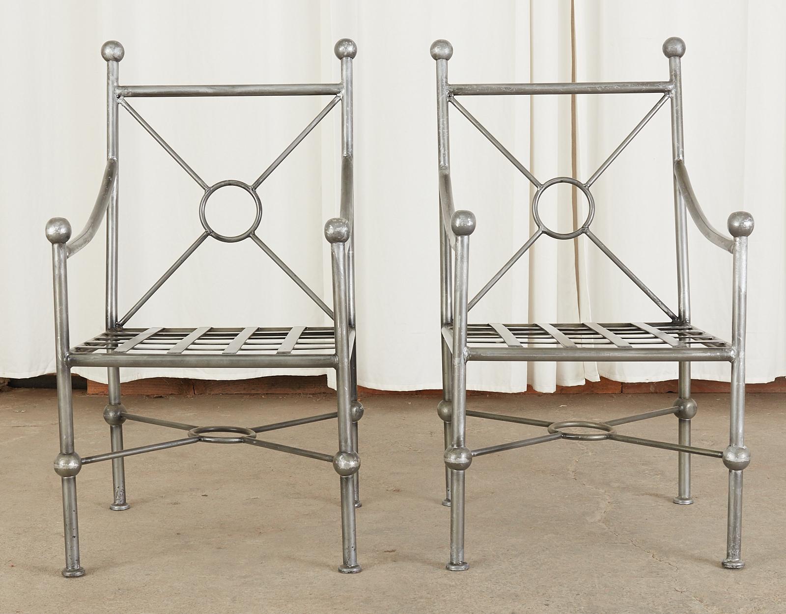 Rare set of four cast aluminum patio and garden dining armchairs featuring an aged silver metallic finish. Crafted in the iconic manner and style of Mario Papperzini for John Salterini having x form target motifs and ball finials in the neoclassical