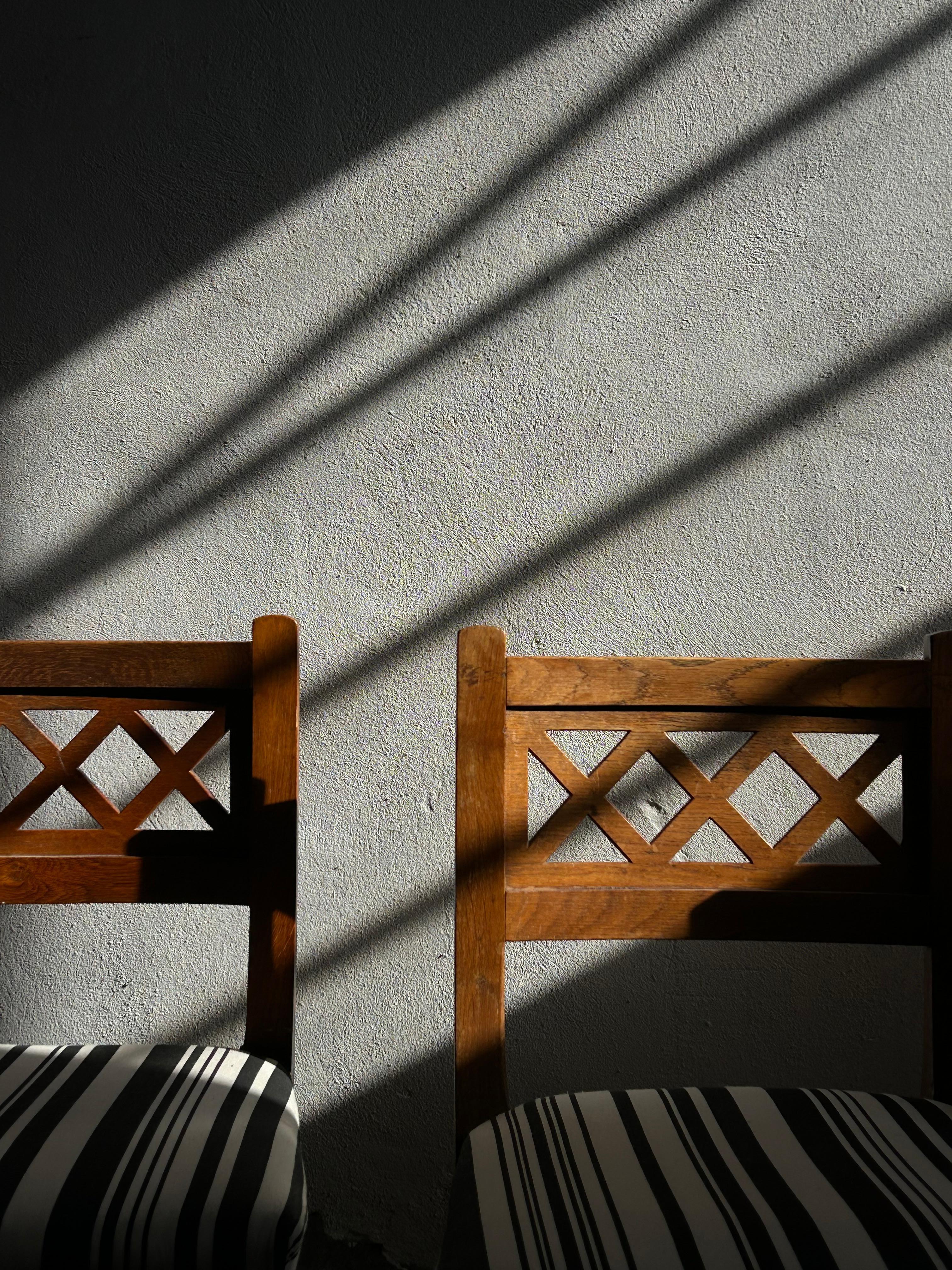 A rare set of four solid oak chairs, designed by Martin Nyrop for Copenhagen City Hall around 1905 and crafted by the esteemed Rud. Rasmussen cabinetmakers. These chairs feature pierced backrests with Nyrop’s signature architectural detailing,