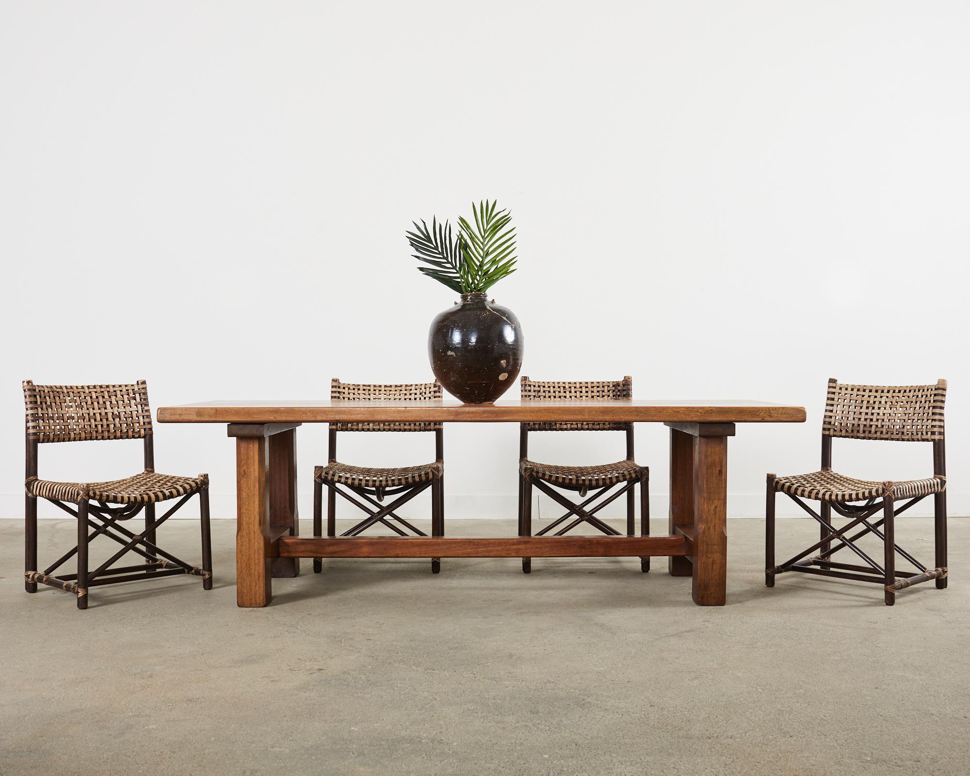 Iconic set of four laced rawhide rattan dining chairs made in the California coastal organic modern style by McGuire. The Antalya chair (model #MCLM44) features a rattan pole frame woven with leather rawhide laces. The frame has a directors chair