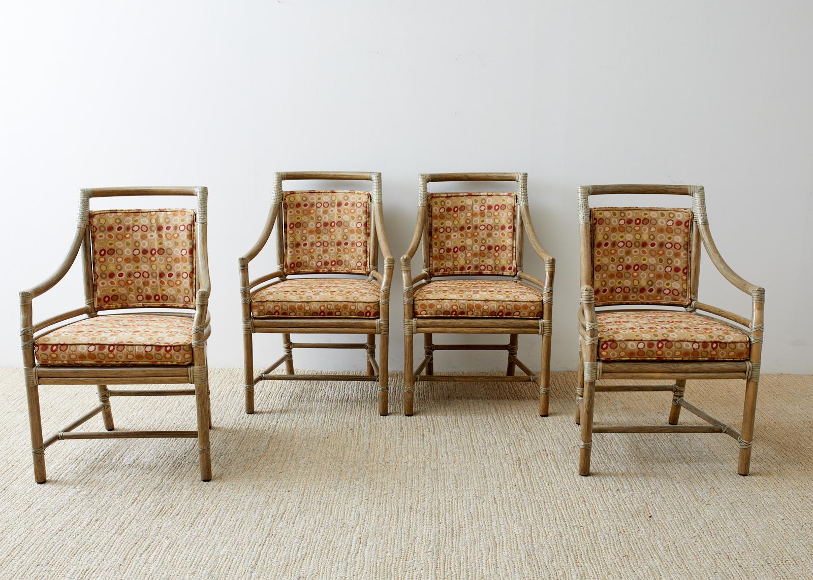 Stylish set of four genuine McGuire bamboo rattan target dining chairs or armchairs designed by Elinor McGuire. The frames feature the famous target motif on the back splat and are finished in bespoke mushroom shade. Upholstered with a midcentury