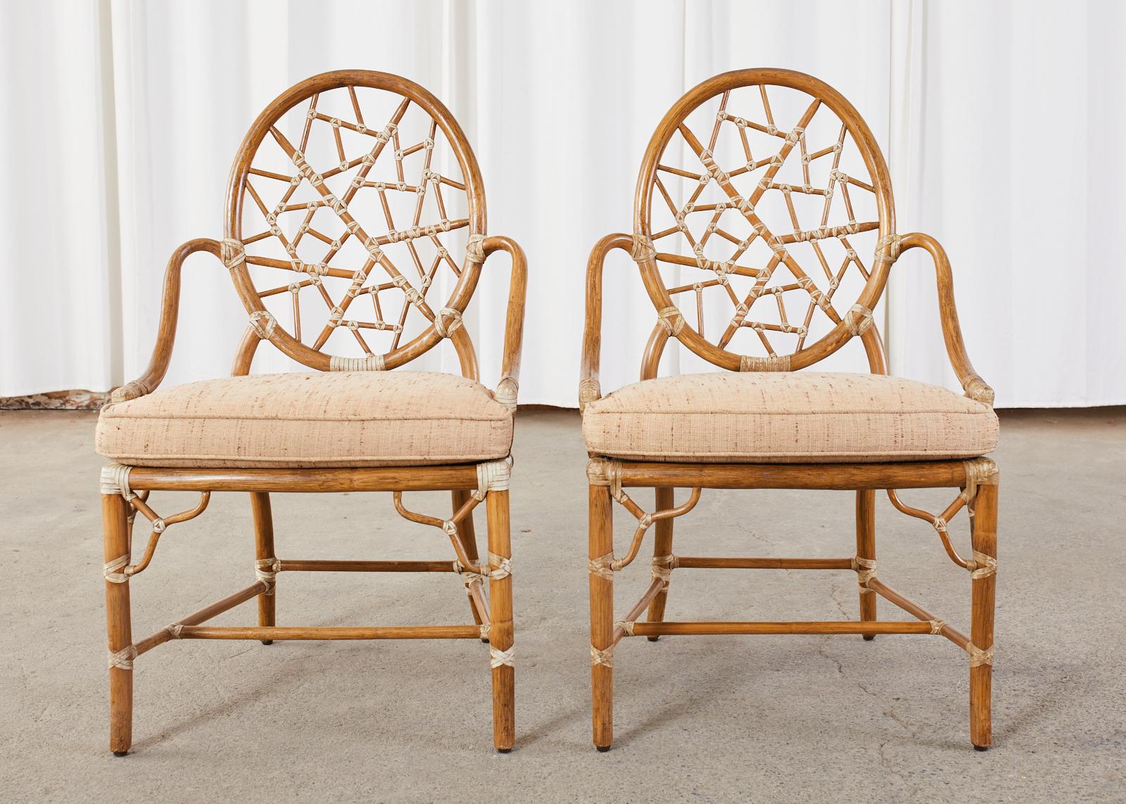 Iconic set of four rattan and cane dining chairs made in the California organic modern style by McGuire. The chairs feature on oval back inset with an open fretwork design resembling cracked ice or shattered glass. Created by Elinor McGuire in 1968