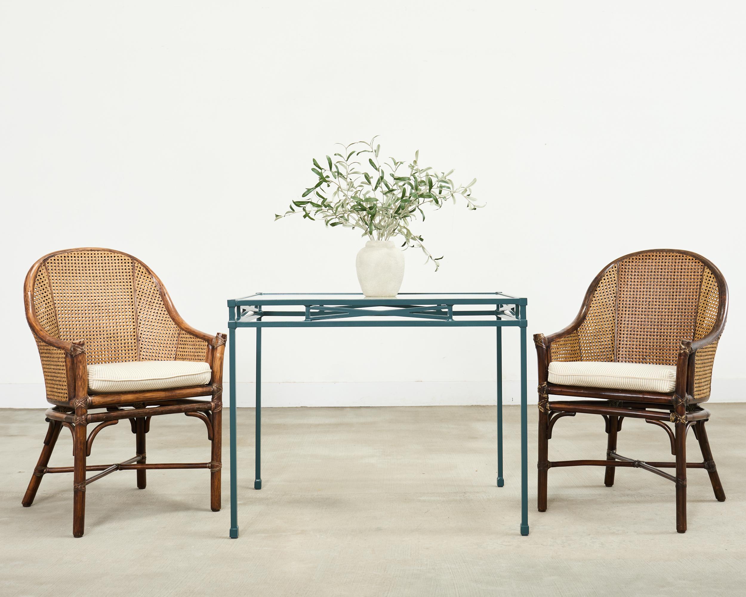 Ensemble de quatre chaises de salle à manger organiques modernes du 20e siècle à dossier en tonneau, fabriquées dans le style côtier californien par les artisans de McGuire. Les chaises sont dotées d'un cadre en rotin gracieusement courbé, relié par