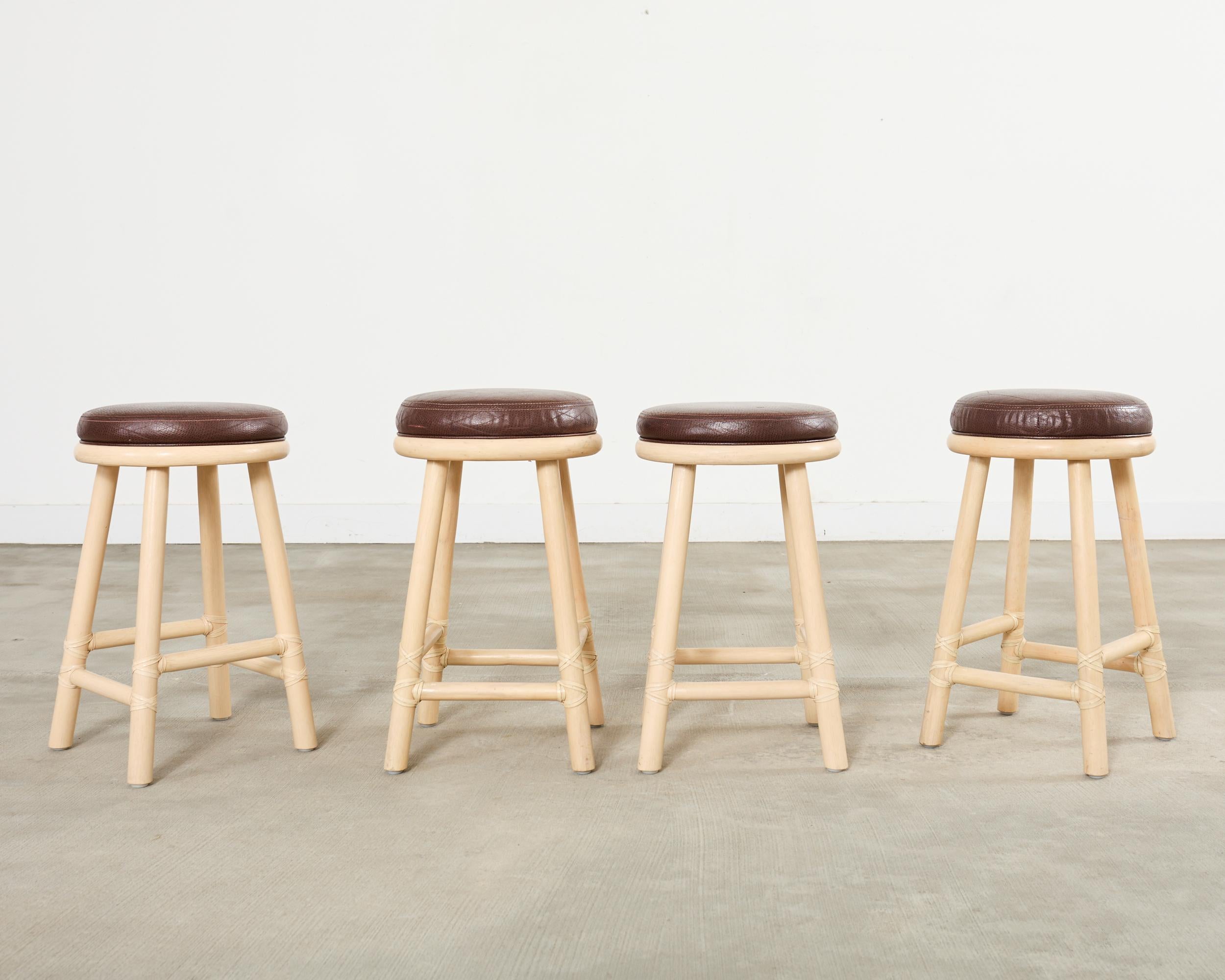 Bespoke set of four counter height non-swivel barstools crafted in the California coastal organic modern style by McGuire artisans. The stools feature a thick pole rattan frame having a stylish ecru lacquered finish. Custom ordered from McGuire with