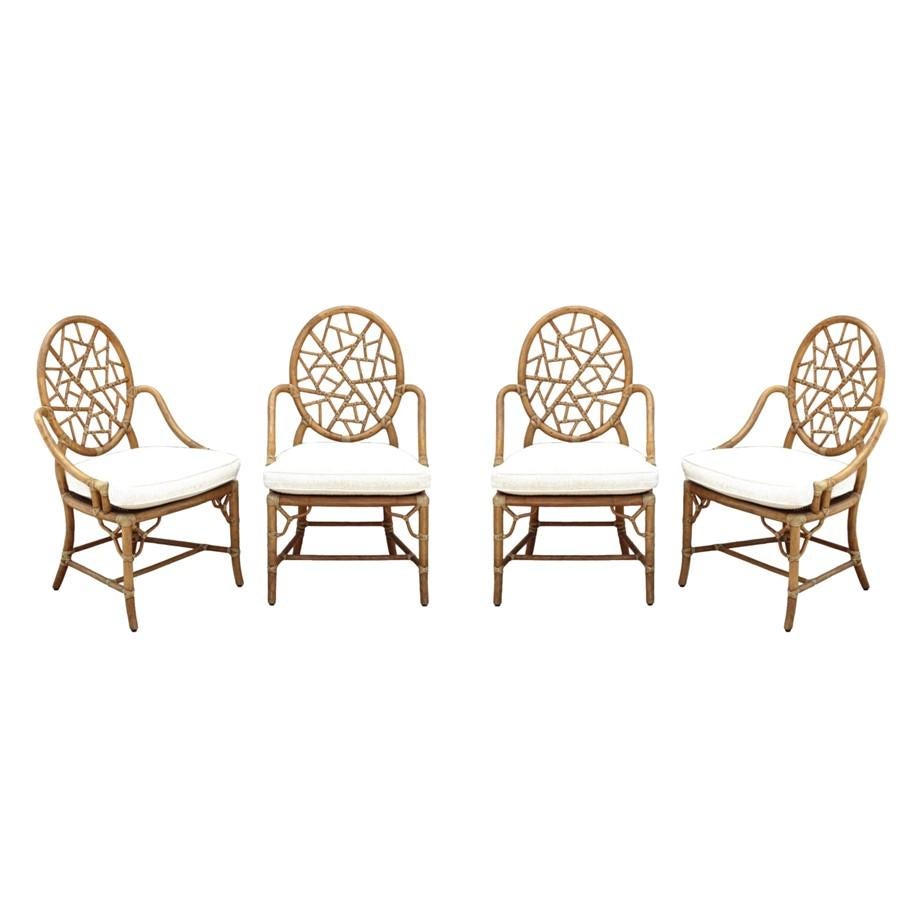 A set of four iconic genuine McGuire Cracked Ice rattan bamboo dining chairs designed by breakthrough innovator Elinor McGuire in 1968. Each armchair retains a McGuire maker's plaque and an inlaid pearlescent M for authenticity. The design is famous