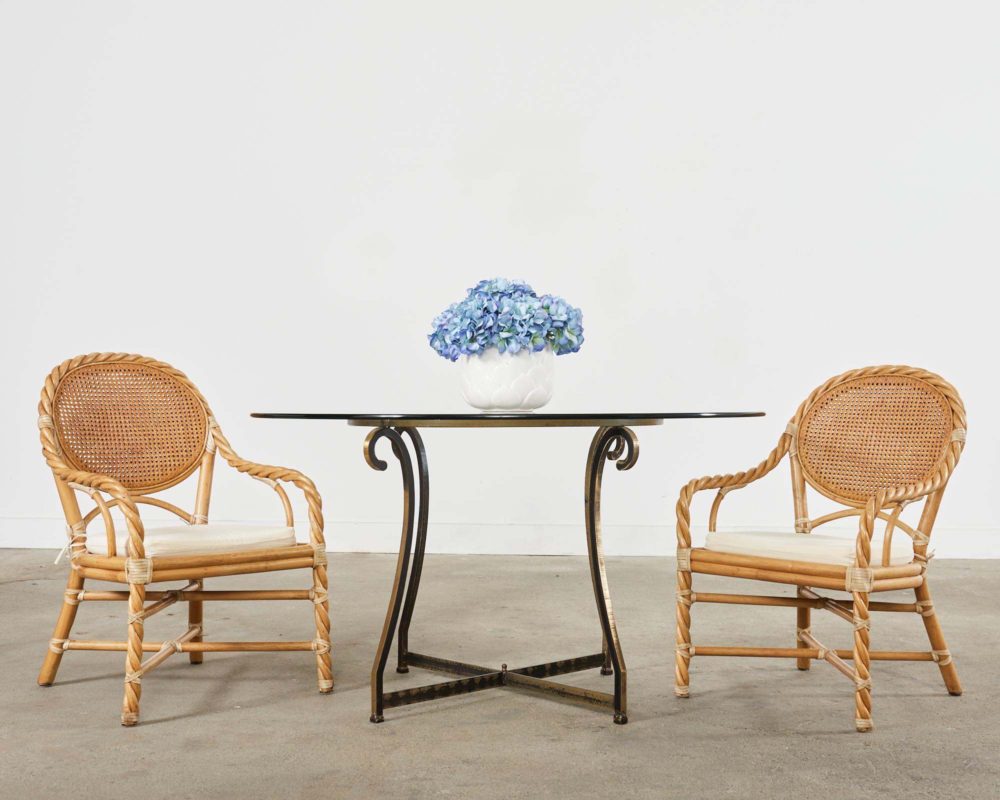 Amazing set of four twisted rattan dining armchairs made in the California coastal organic modern style by McGuire, San Francisco. The bespoke chairs feature a braided pole rattan frame that starts at the legs, then becomes the arms, and gracefully