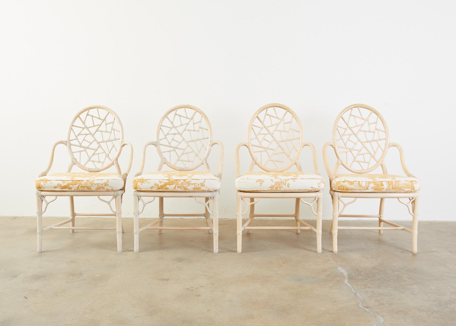 Fantastic set of four genuine McGuire bamboo rattan dining chairs. The chairs feature an iconic design by Elinor McGuire of a cracked ice open fretwork back. Handcrafted from pieces of rattan joined by leather rawhide laces. The chairs have a caned