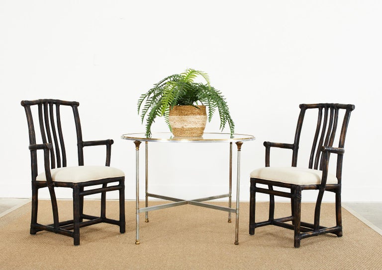 Dramatic set of four rattan dining chairs made by McGuire. The chairs are made in the manner and style of a Chinese Ming officials hat chair crafted from rattan poles lashed together with leather rawhide laces. The rattan has an intentionally aged
