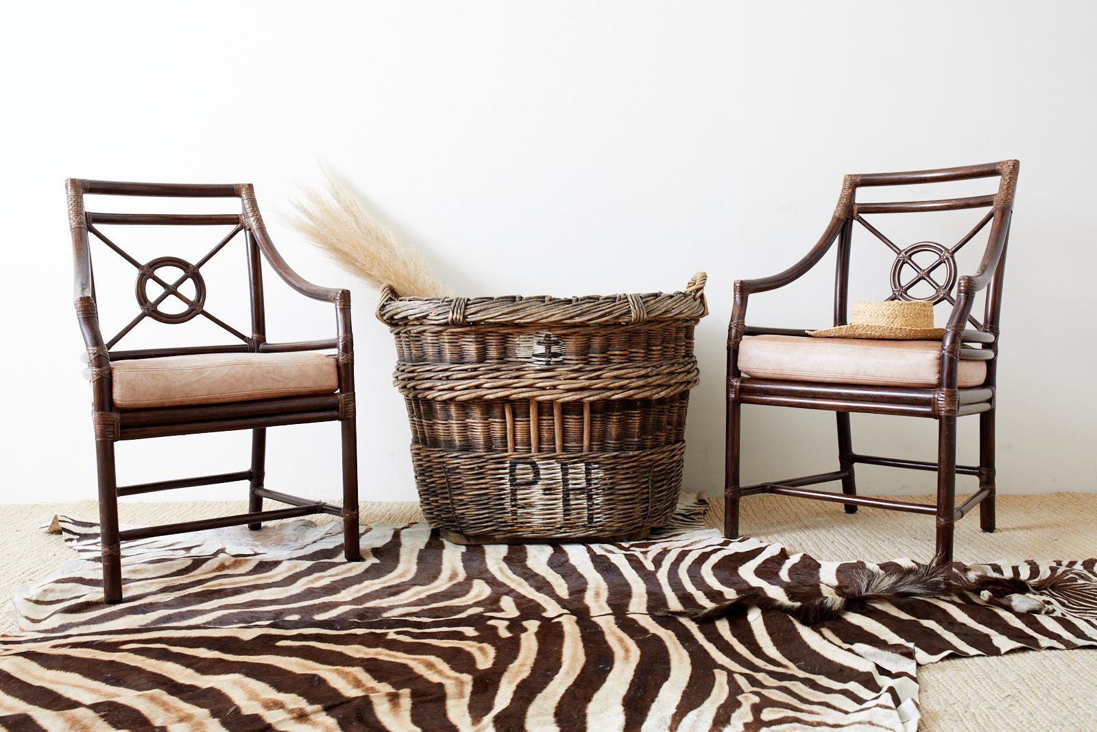Classic set of four genuine McGuire target design armchairs or dining chairs. Designed by Elinor McGuire the frame features the famous target motif on the backsplat. Handcrafted bamboo rattan frame lashed together with leather rawhide laces.