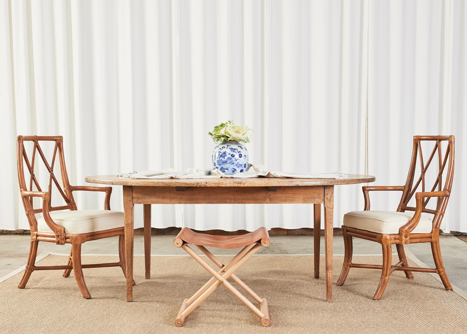 Gorgeous set of four organic modern dining chairs hand-crafted from rattan made in the manner and style of McGuire by David Francis Vero Beach, Florida. The set consists of one side chair and three armchairs measuring 24 inches wide and having 25