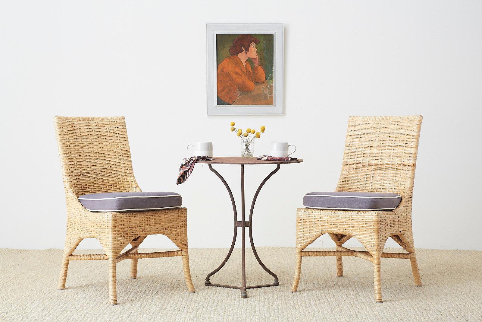 California organic modern style dining chairs made by McGuire furniture. Featuring a handcrafted rattan pole frame covered with woven wicker. The square back gracefully integrates into the seat accented by arches on the seat apron stretchers.