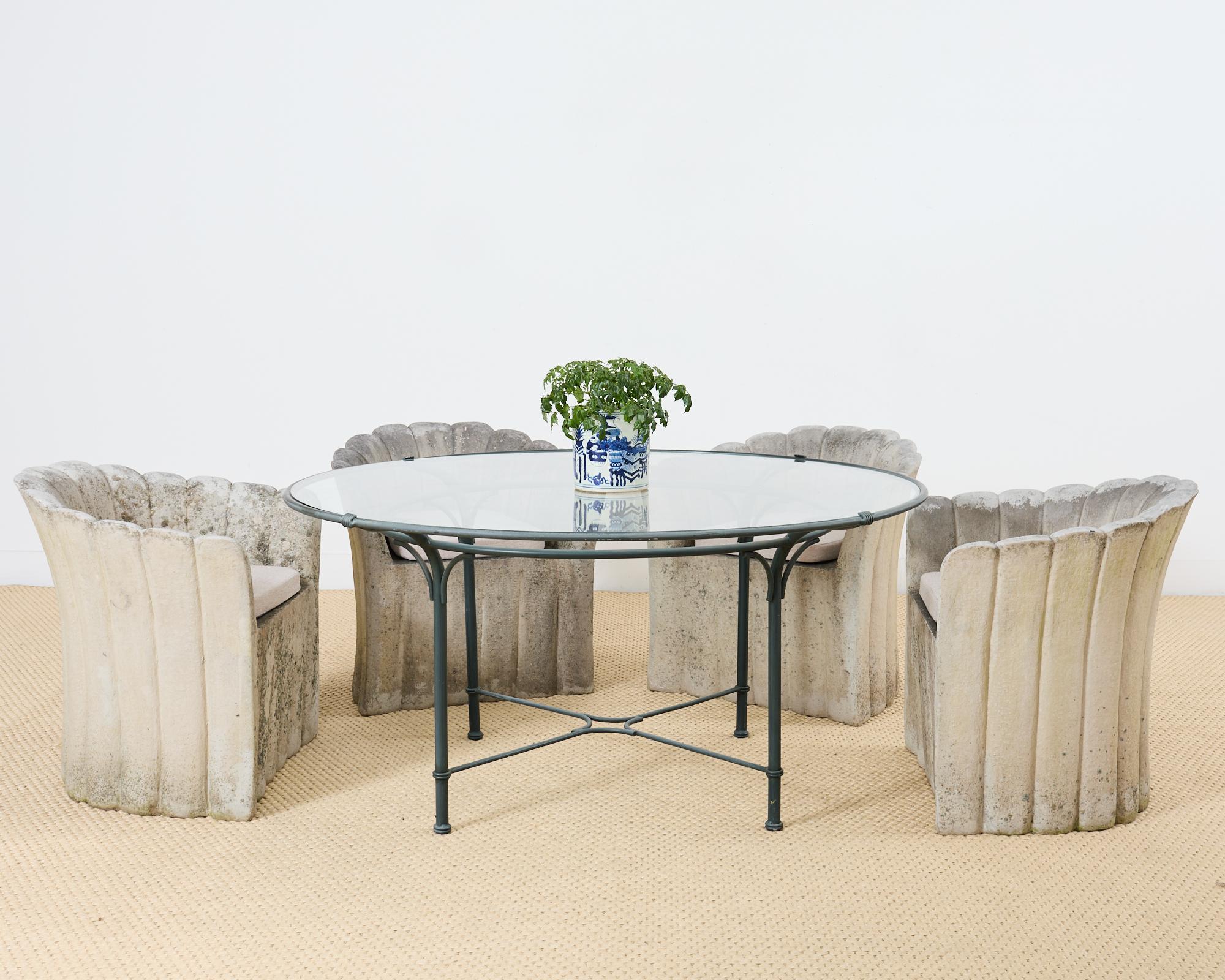Amazing set of four patio and garden faux-stone composite armchairs made in the style of Michael Taylor. The chairs feature a concrete or molded stone style of finish having an aged patina with stains and lichen to mimic age. The one piece forms