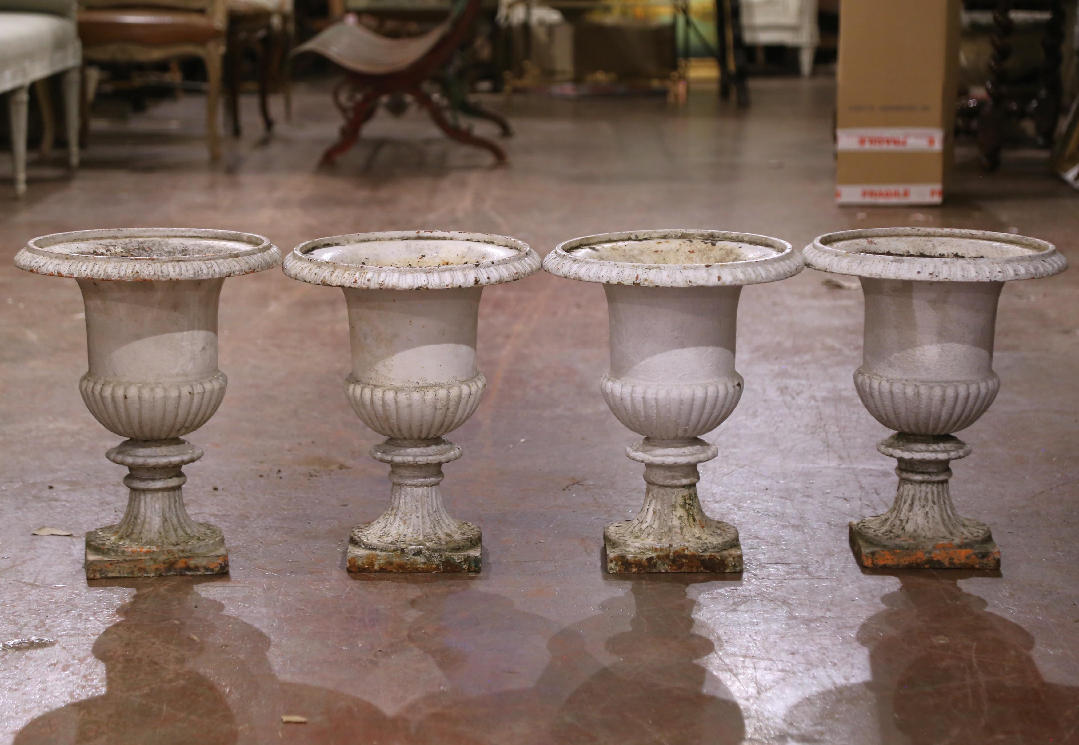 Este elegante juego de cuatro jarrones Medici del siglo XIX se fabricó en Francia hacia 1860 y refleja la grandeza atemporal del diseño clásico de jardines. Fabricados en hierro fundido, cada recipiente presenta la icónica forma Medici, con labio