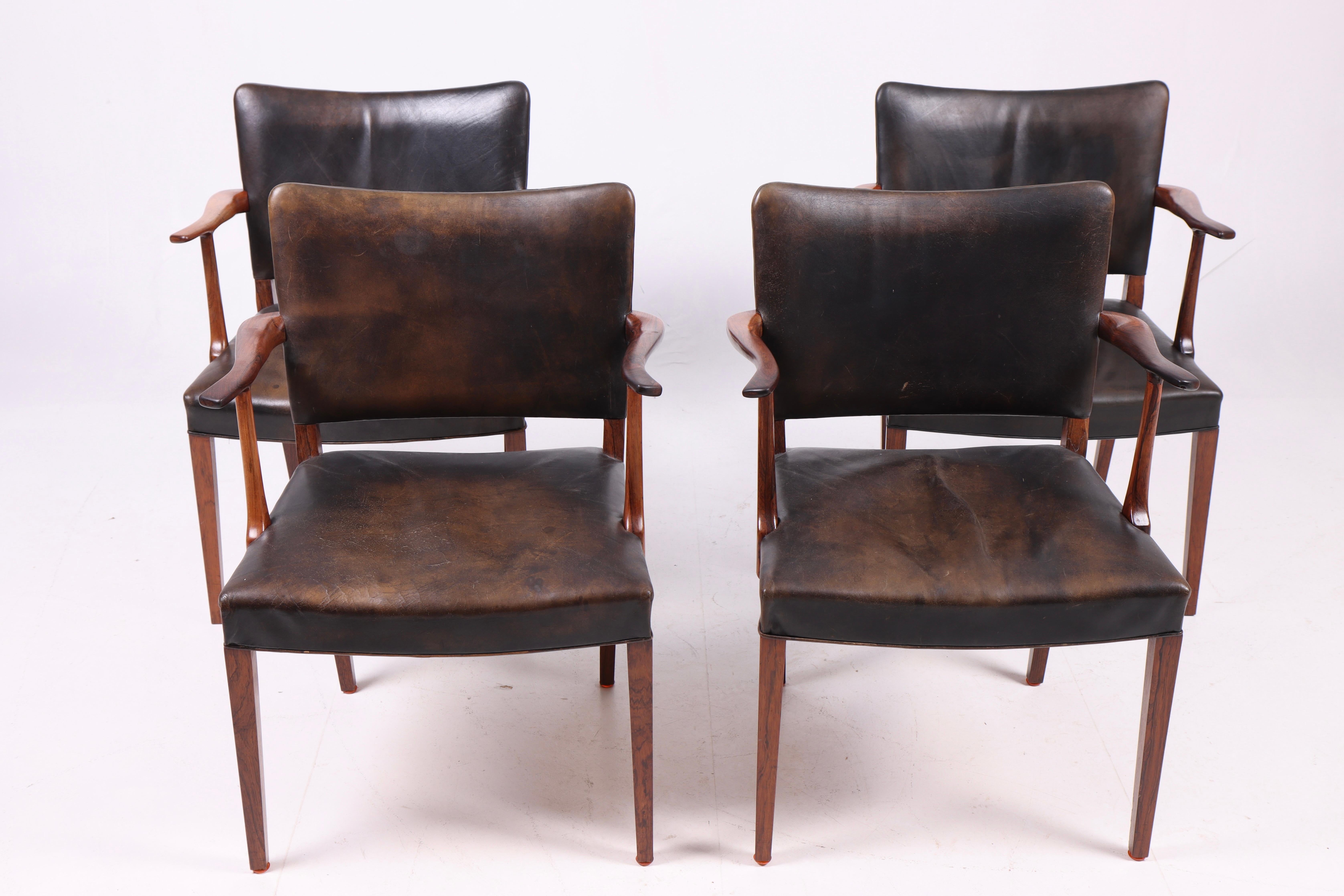 Set di quattro poltrone in legno di palissandro e pelle patinata disegnate e realizzate da Rasmus Nielsen negli anni Cinquanta. Prodotto in Danimarca. Ottime condizioni.