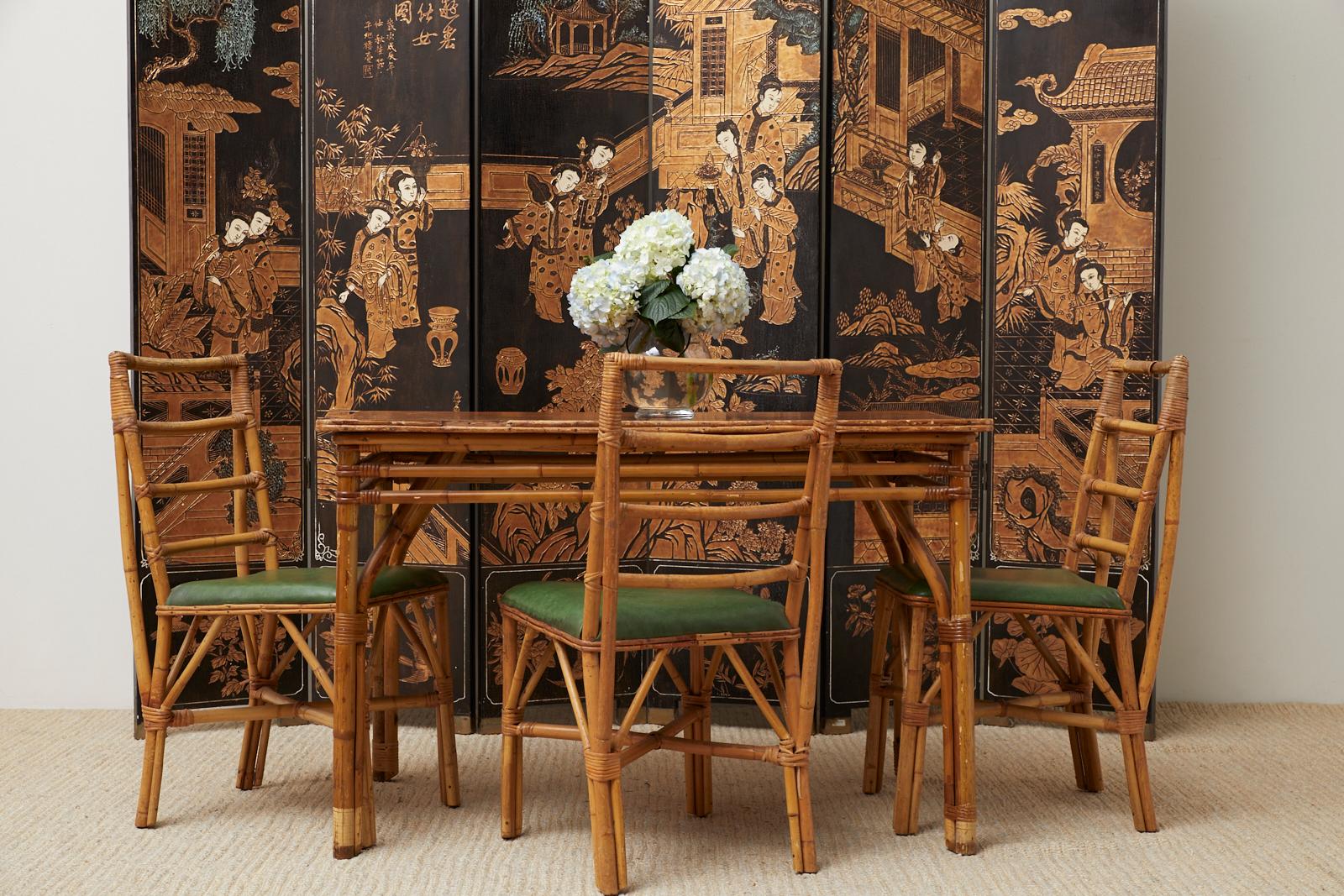 Distinctive set of four Mid-Century Modern dining chairs constructed from handcrafted bamboo rattan poles. The chairs feature a ladder back style with bamboo reinforced backs and cross stretchers conjoining the legs. The chairs have rattan slashing