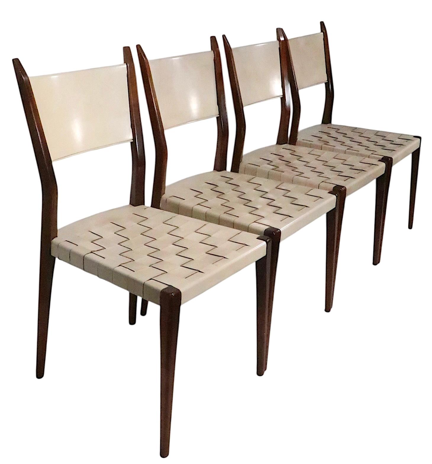 Chic and sophisticated set of four Mid Century dining chairs, made by Calvin Furniture, designed by Paul McCobb as part of the sought after Irwin Collection, circa 1950's. The chairs feature woven leather seats, leather back rests and  graceful,
