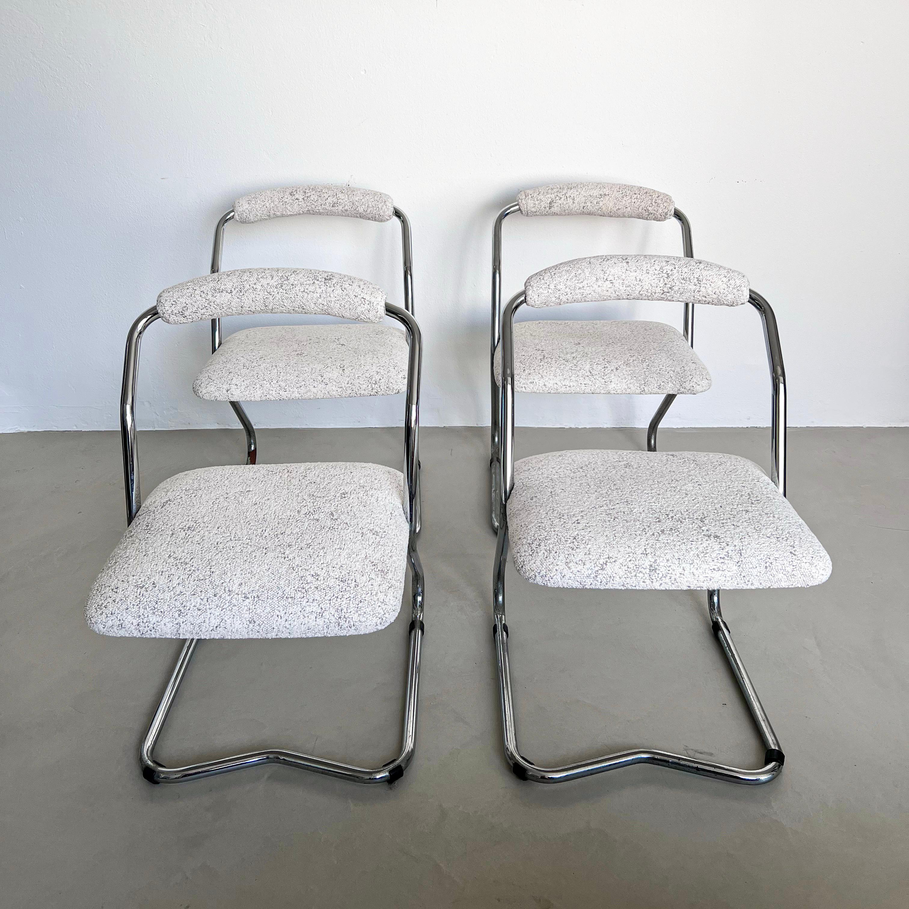 Decorative Dining Chairs - White Bouclé Chairs - Chromed Cantilever Chairs

Set of four Mid-Century Modern / Space Age dining chairs, with a decorative continuous tubular frame in chromed metal, upholstered seat and upholstered roll backrest. The