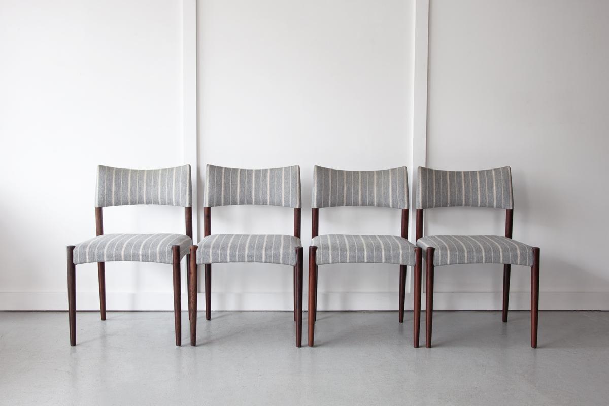 A set of four Danish dining chairs with beautiful rosewood frames. They are upholstered in grey striped wool. This is the original upholstery which is in good vintage condition with no tears but with some signs of light discolouration in areas. 