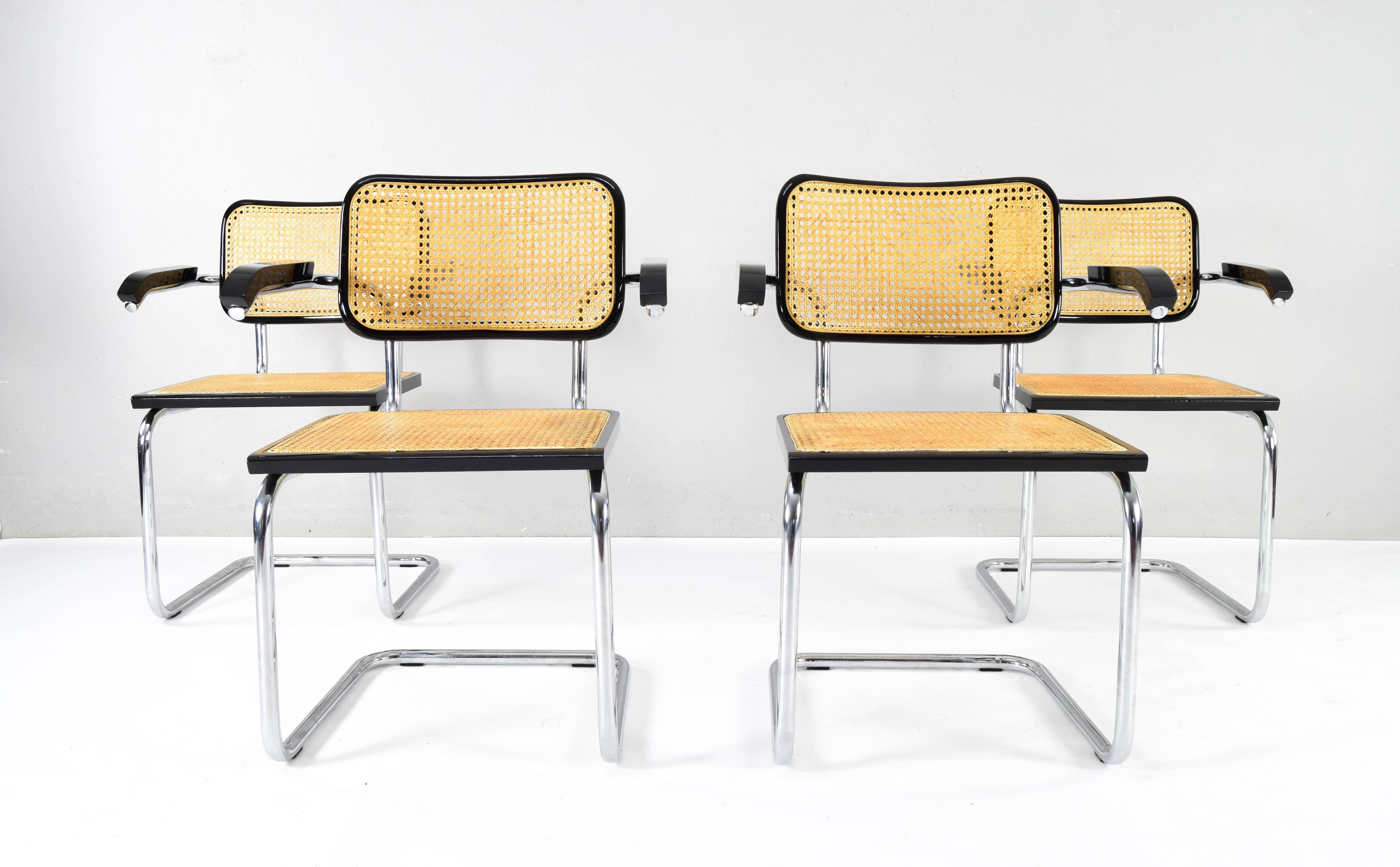Set of four Cesca chairs model B64, with armrests.
The tubular chrome steel structure is in good condition.
Black lacquered beech wood frames and natural Viennese grille.
The grilles on all four seats have been replaced.

Armrest height: 69cm