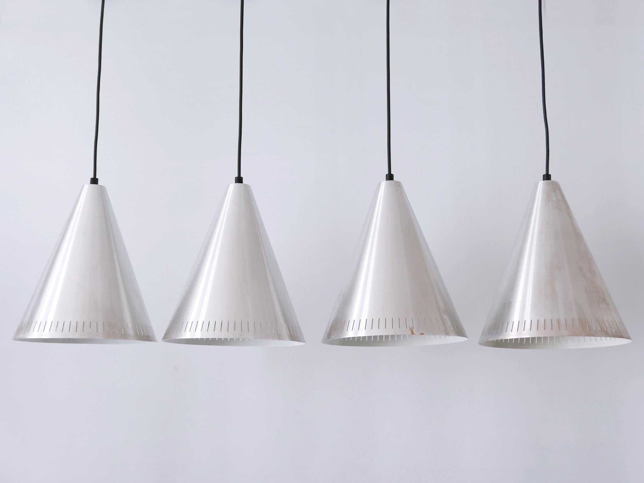 Set of four elegant Mid Century Modern perforated aluminium pendant lamps. Designed and manufactured by Goldkant Leuchten, Germany, 1970s. Label inside the lamp shades.

Executed in perforated aluminium, each pendant lamp has 1 x E27 / E26 Edison