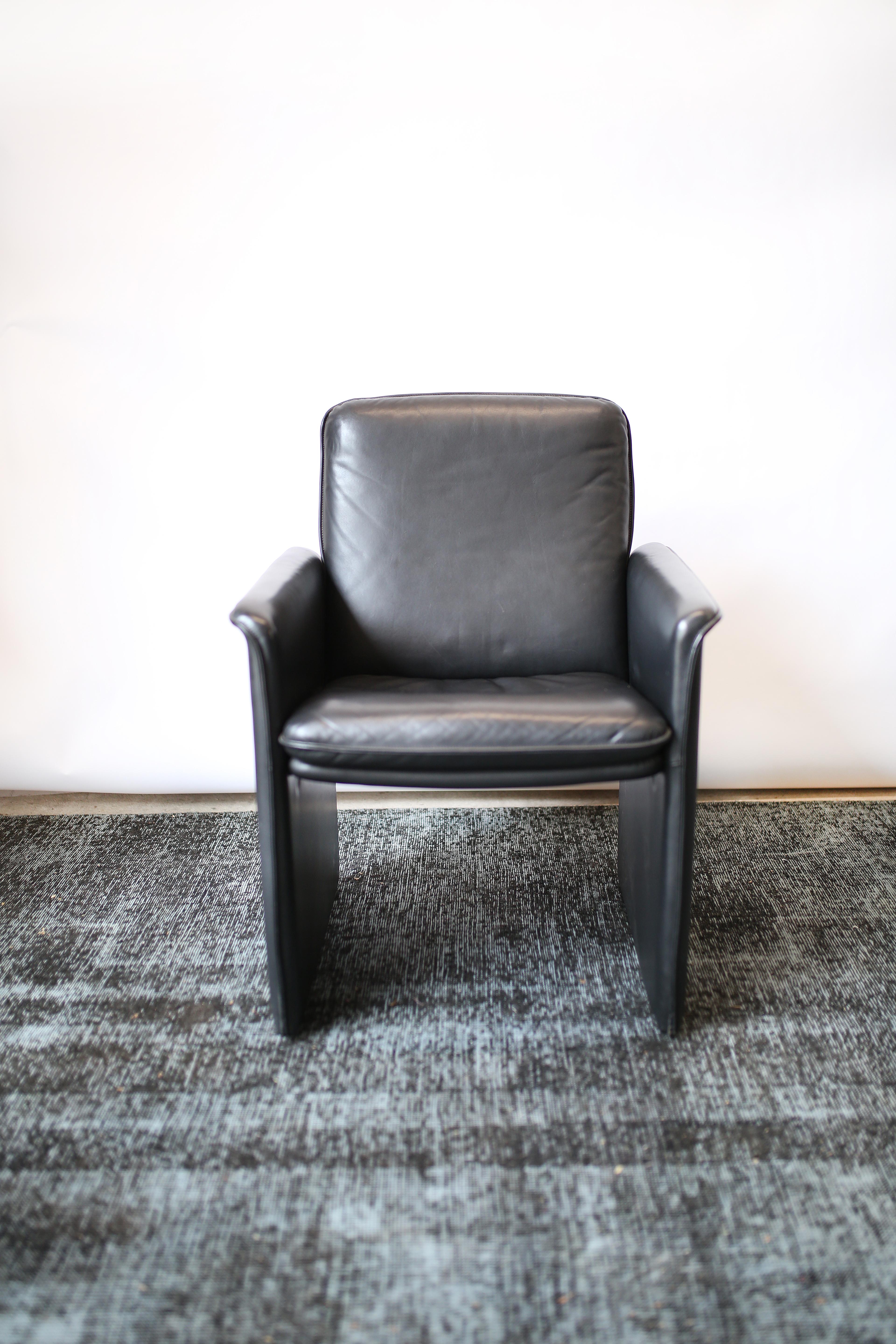 This set of four mid-century modern solid black leather chairs by Swiss company De Sede are in overall very good condition and wear consistent with age and use. Supple black leather. Scandinavian modern design.  
circa 1970s.