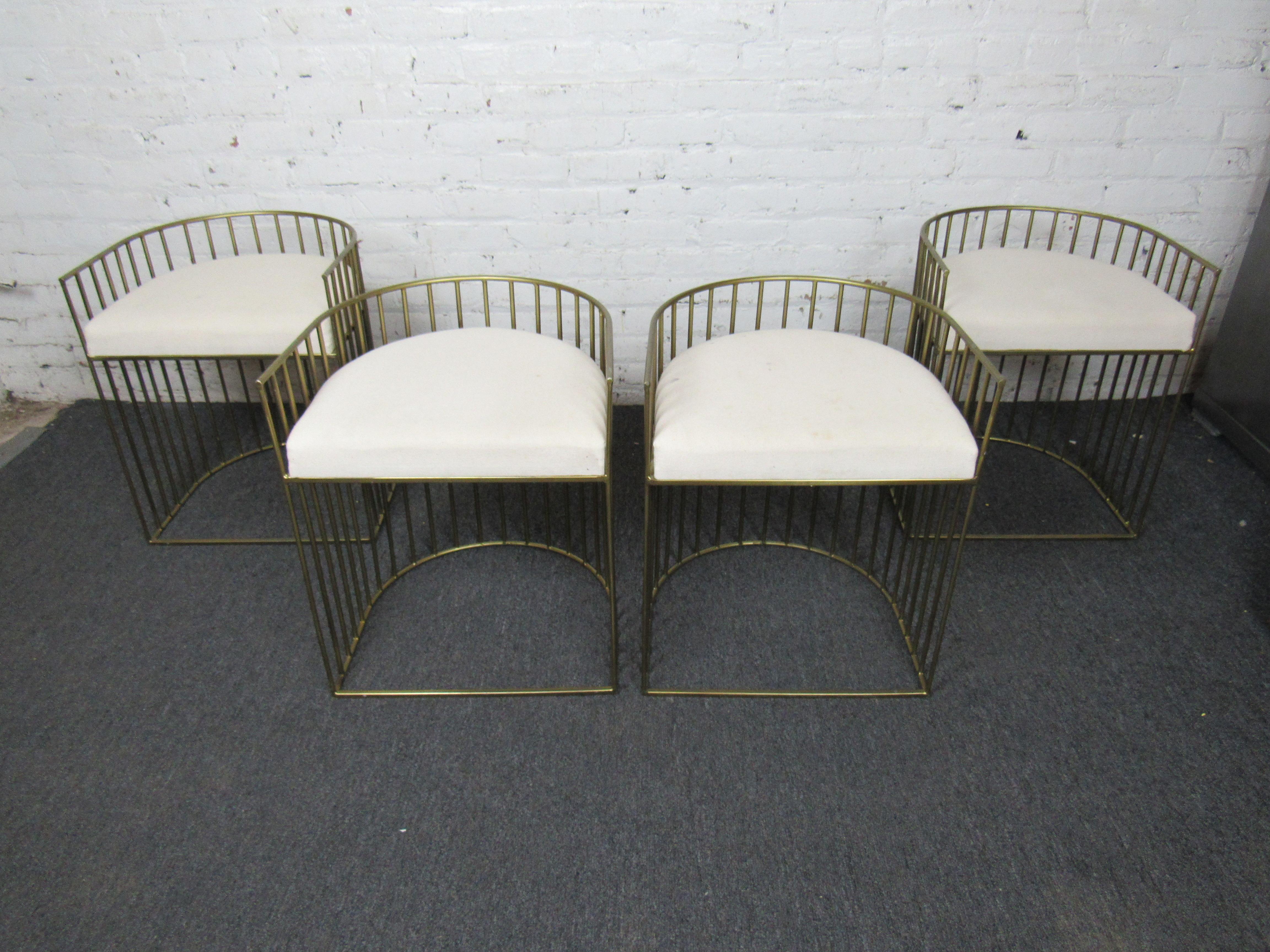 An incredible set of four Mid-Century Modern chairs in brass and white cushions. A unique design with rounded backs makes these chairs both comfortable and attractive. Please confirm item location with seller (NY/NJ).