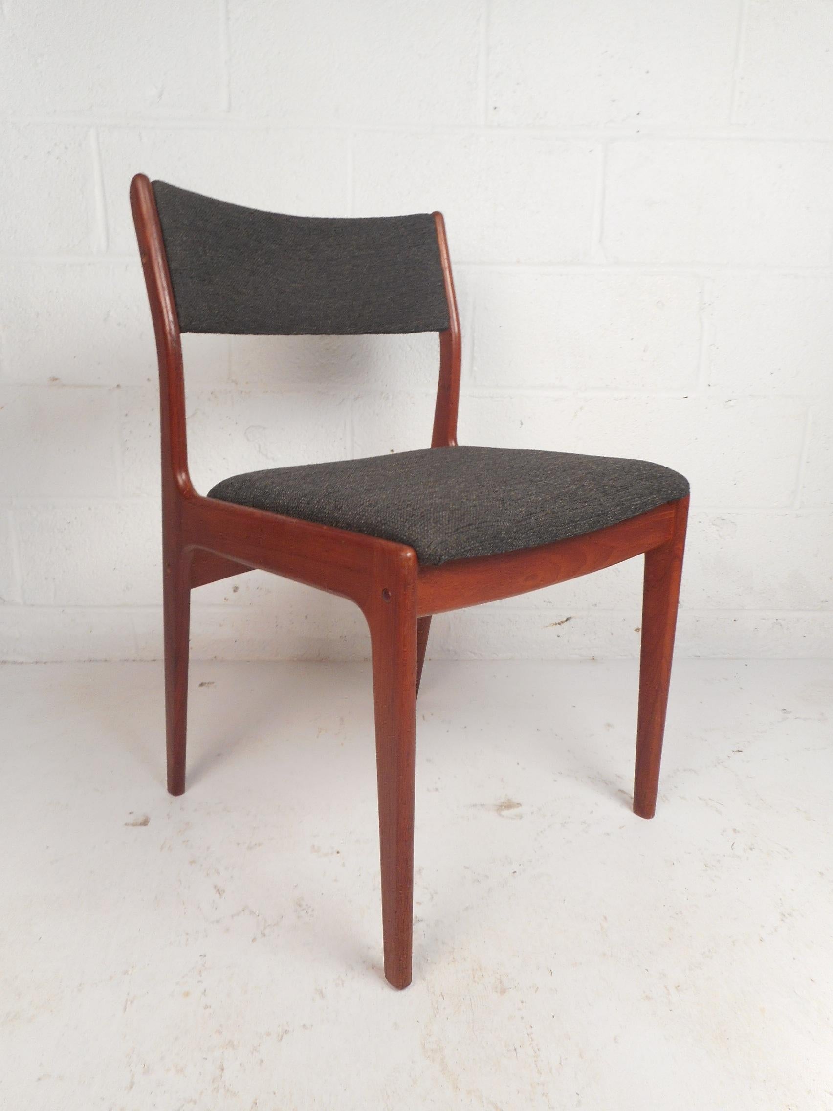 This gorgeous set of four dining chairs feature sculpted teak frames and tapered legs. Sleek design with a curved back rest ensuring maximum comfort without sacrificing style. A thick padded seat and back rest covered in a beautiful dark colored