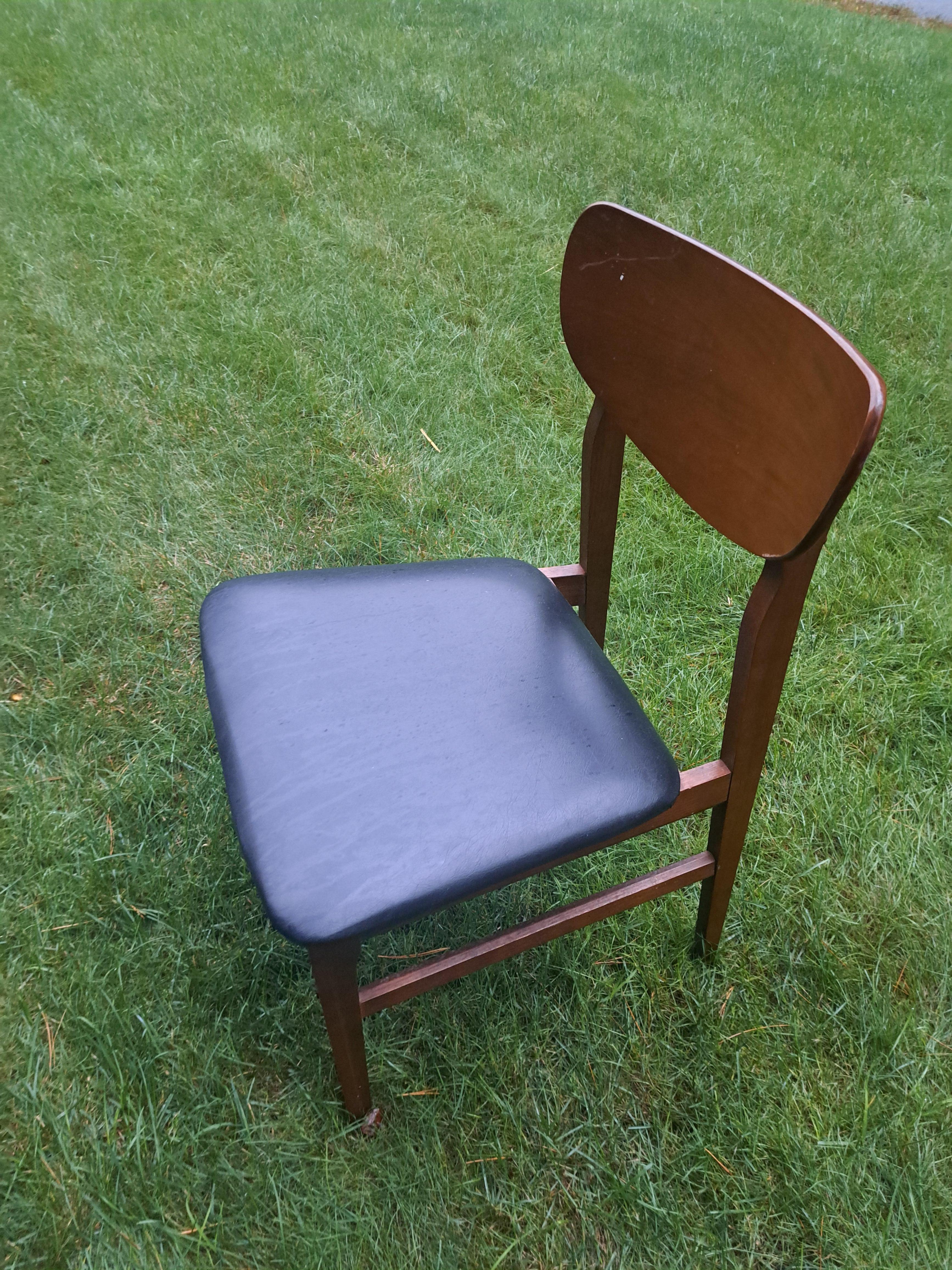 Set di quattro sedie da pranzo in legno con sedute in vinile nero. Il set Modern-Decor ha un aspetto elegante e sobrio che si abbina a qualsiasi arredamento. Le sedie sono in buone condizioni vintage con qualche graffio sul legno.