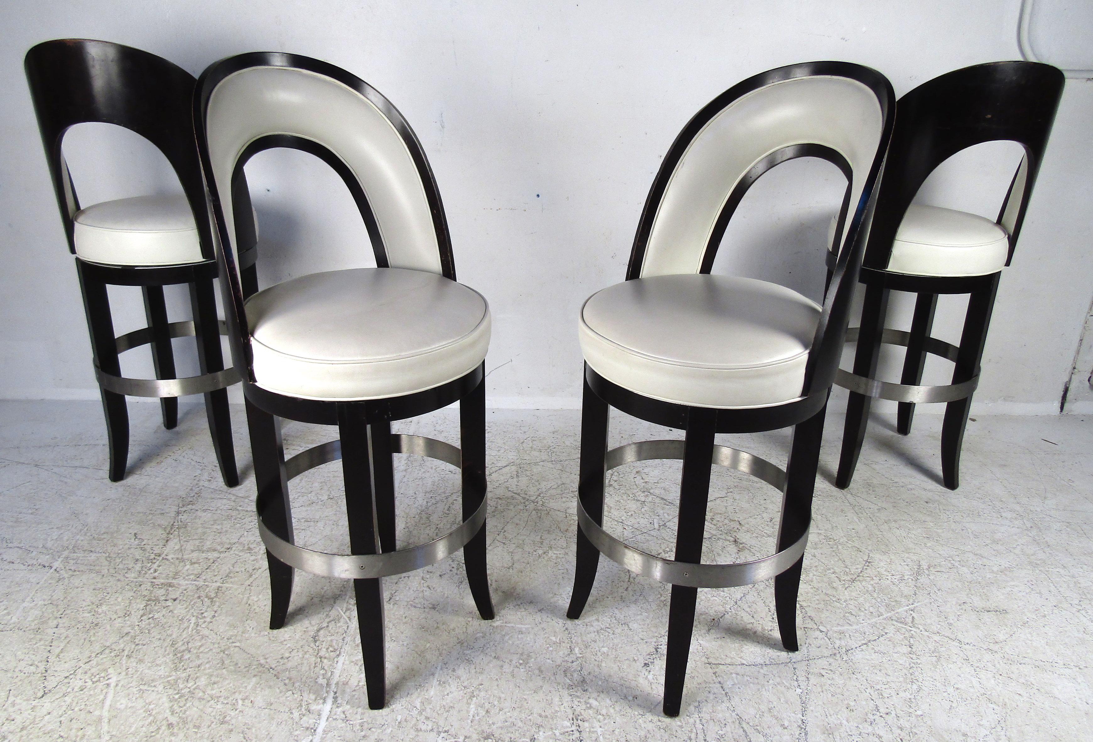 This stunning set of four vintage modern Italian barstools feature a two-tone black and white design. The overstuffed seats and backrests are covered in white vinyl. A sturdy wood frame painted in black offers the convenient ability to swivel. A