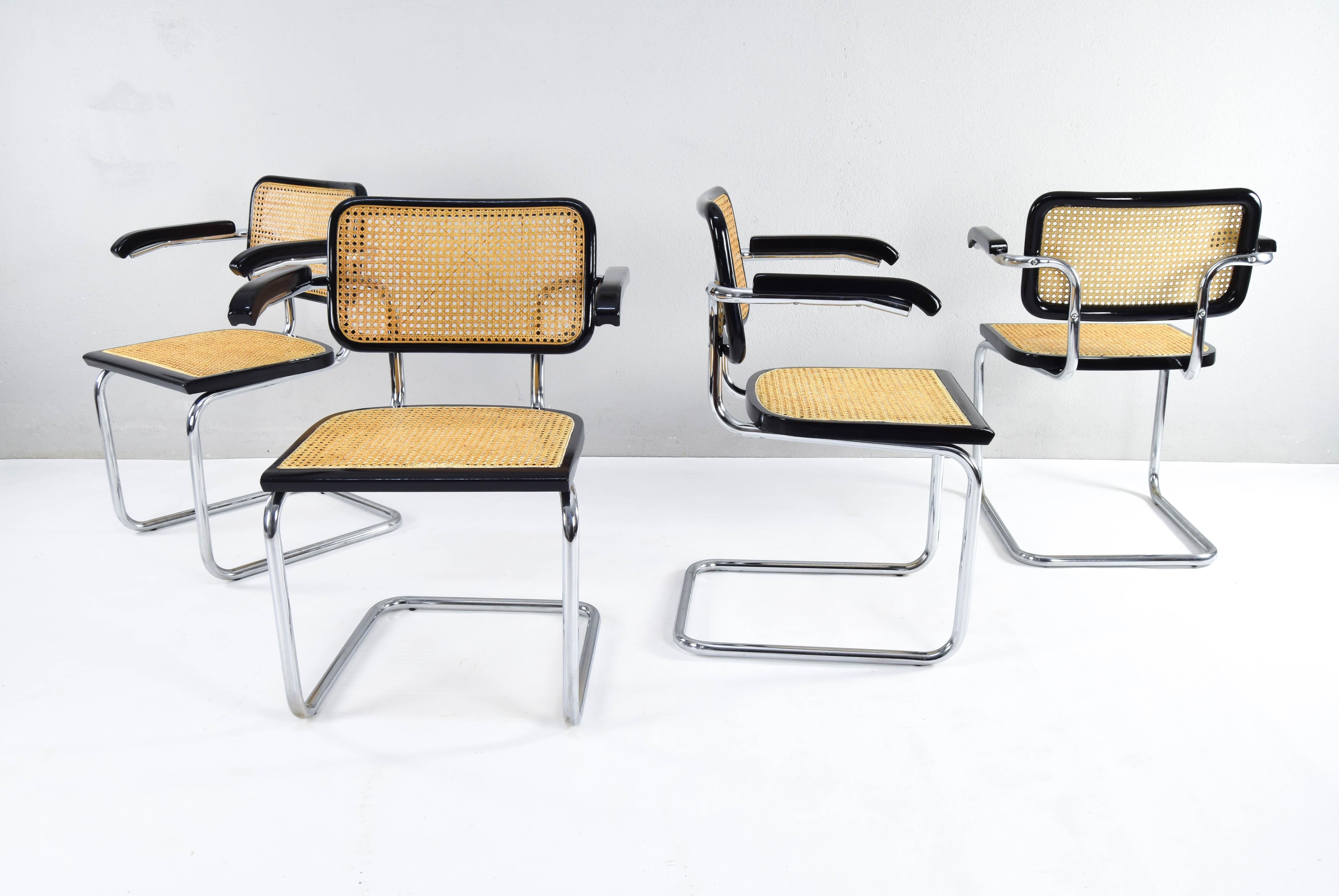 Set of four Cesca chairs model B64, with armrests. Tubular steel chromed structure in good condition (only one of them has an area of wear on the chrome, see last image). 
Beechwood frames lacquered in black and Viennese natural grid. 
Grids of the