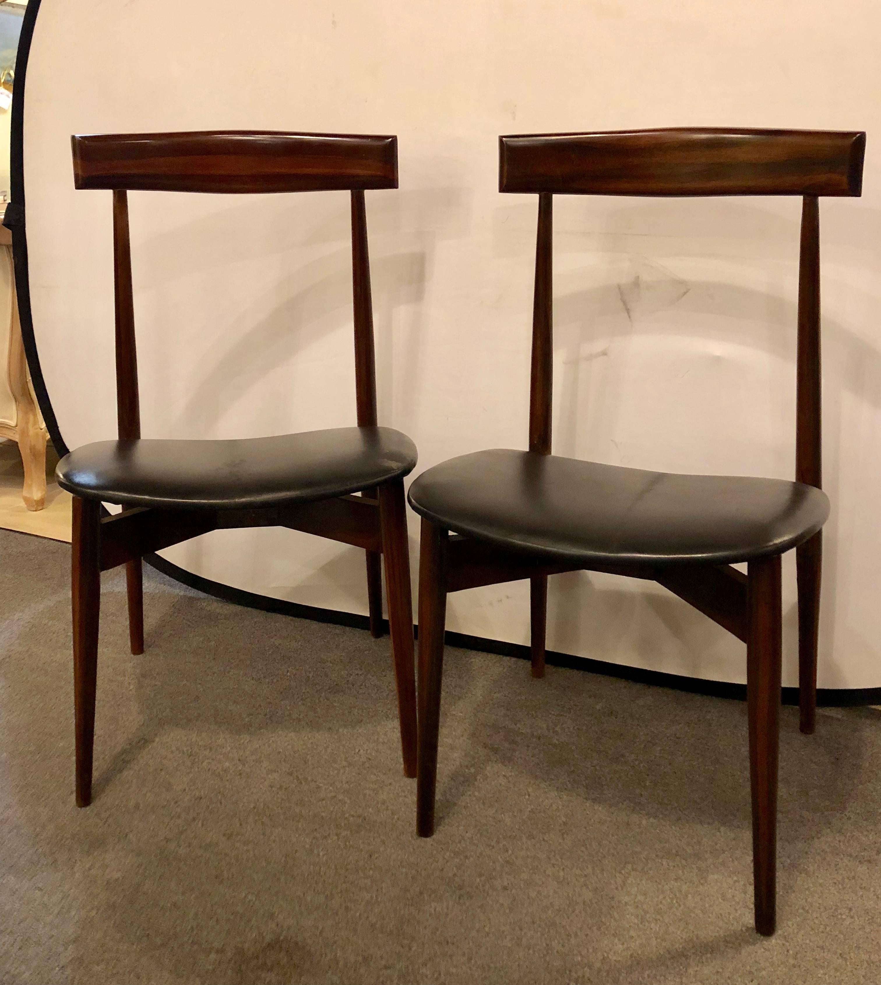 Set of four Mid-Century Modern slat back black leather side chairs. Each in a rosewood finish with new seat cushions.