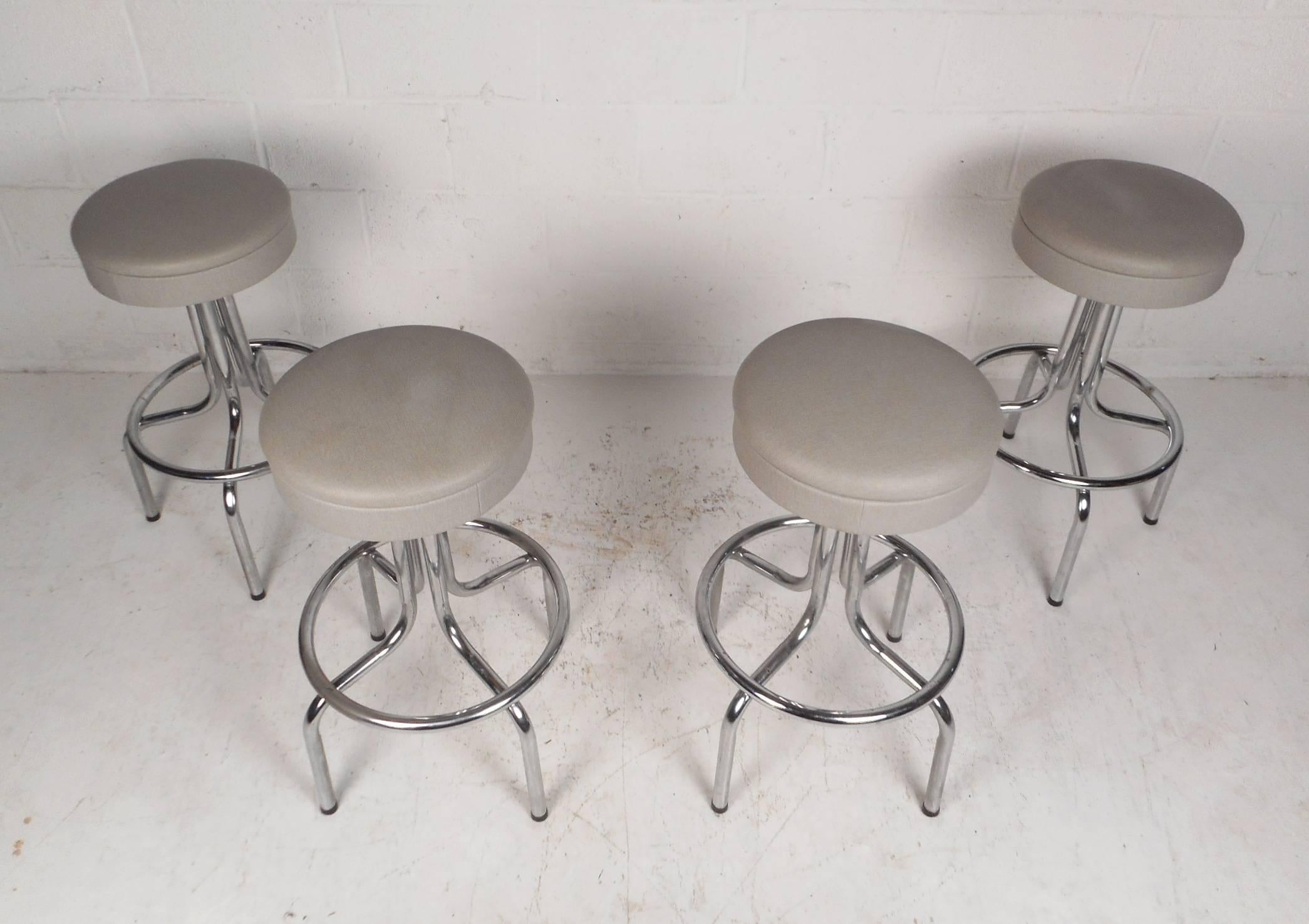 Beautiful set of four vintage modern bar stools with a swivel top and a bent rod chrome base. A thick padded seat covered in a fabulous light grey upholstery ensures maximum comfort and style. Quality construction made by Moreland and Dalton. This