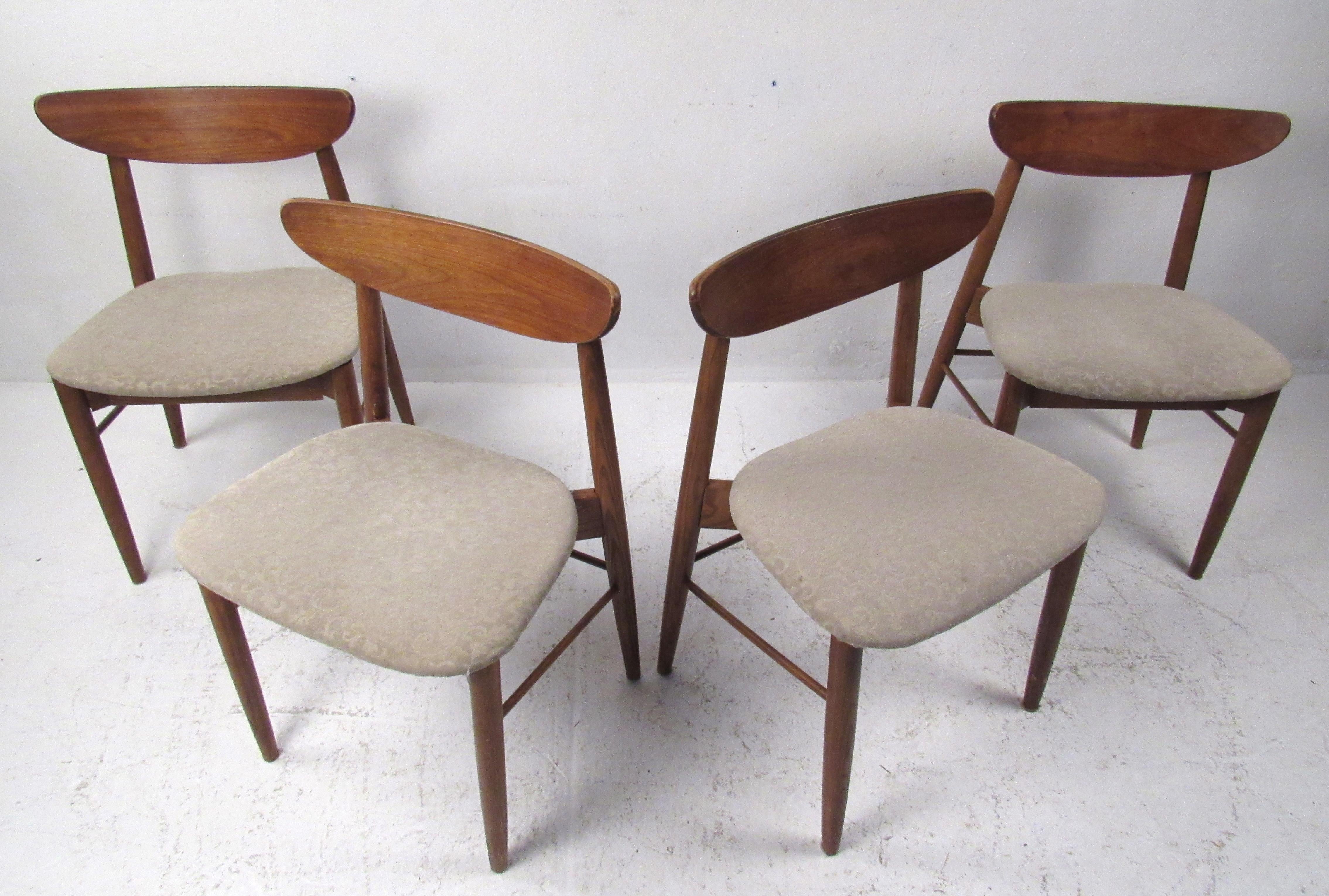 This beautiful set of four vintage modern dining chairs boast curved backrests and tapered legs. The stylish walnut frame and thick padded cushion ensure maximum comfort without sacrificing style. These lovely side chairs make the perfect addition