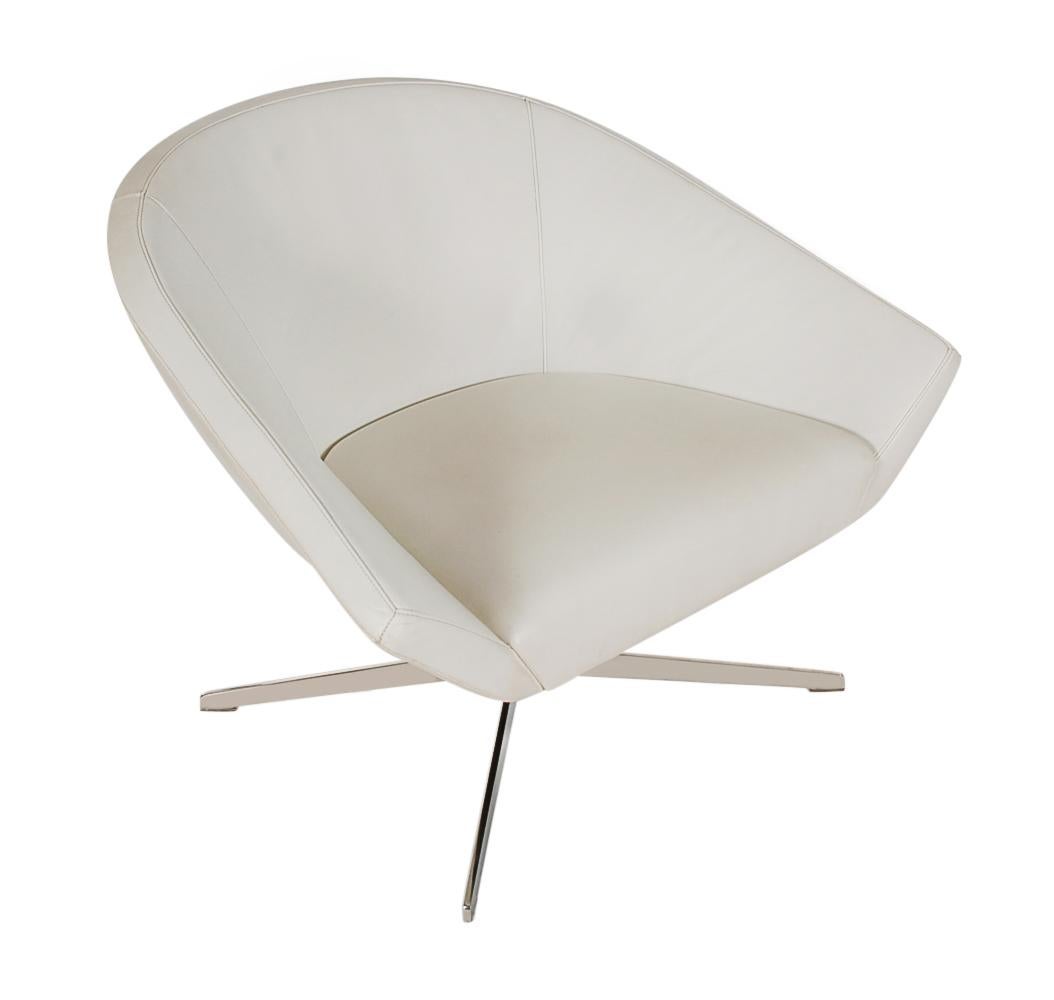 A handsome matching set of 4 swivel lounge chairs made by Bernhardt in the 1990s. These high quality chairs features polished stainless bases, white Naugahyde upholstery, and swiveling bases that return to their original positions. Manufacturers