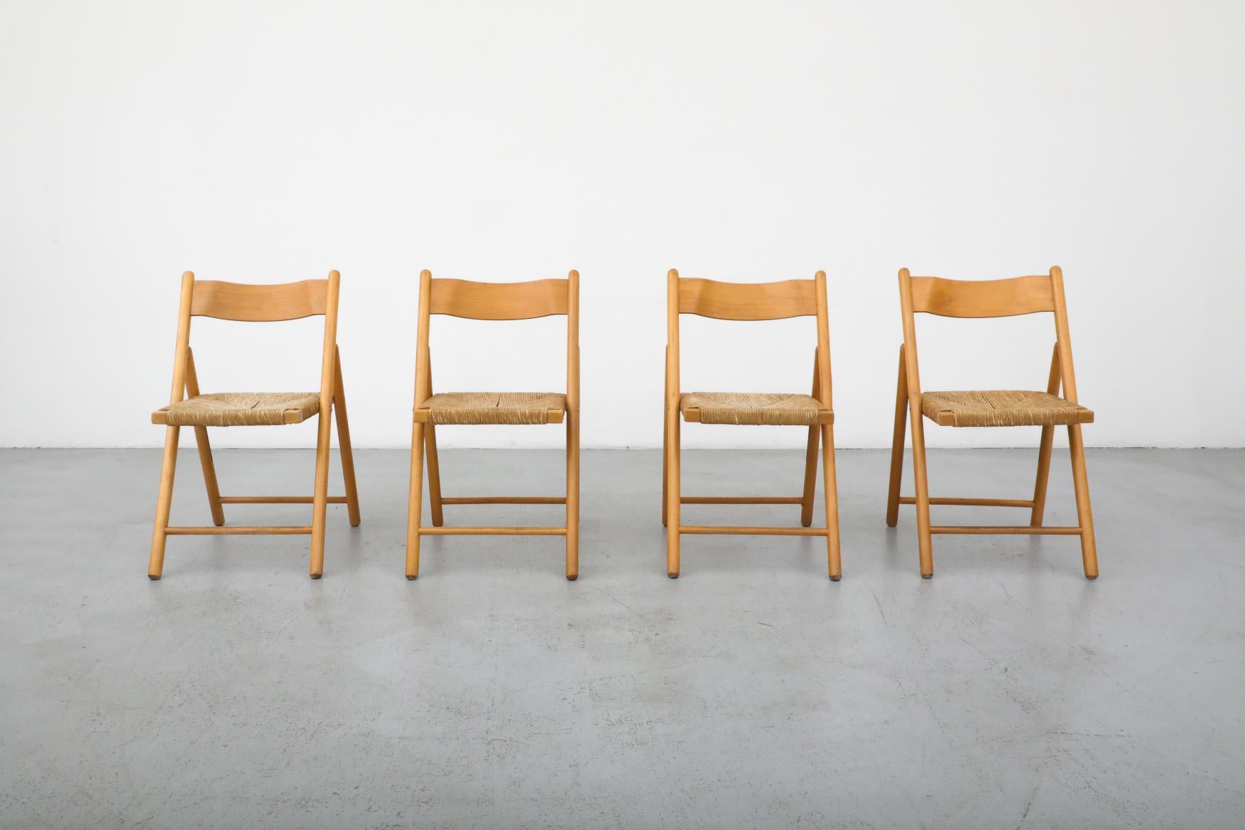 Ensemble de 4 chaises pliantes en chêne du milieu du siècle, avec dossier légèrement incurvé et assise en jonc. En état d'origine, avec une usure et une patine correspondant à l'âge et à l'utilisation. Foldes : 18 x 4 x 35. 