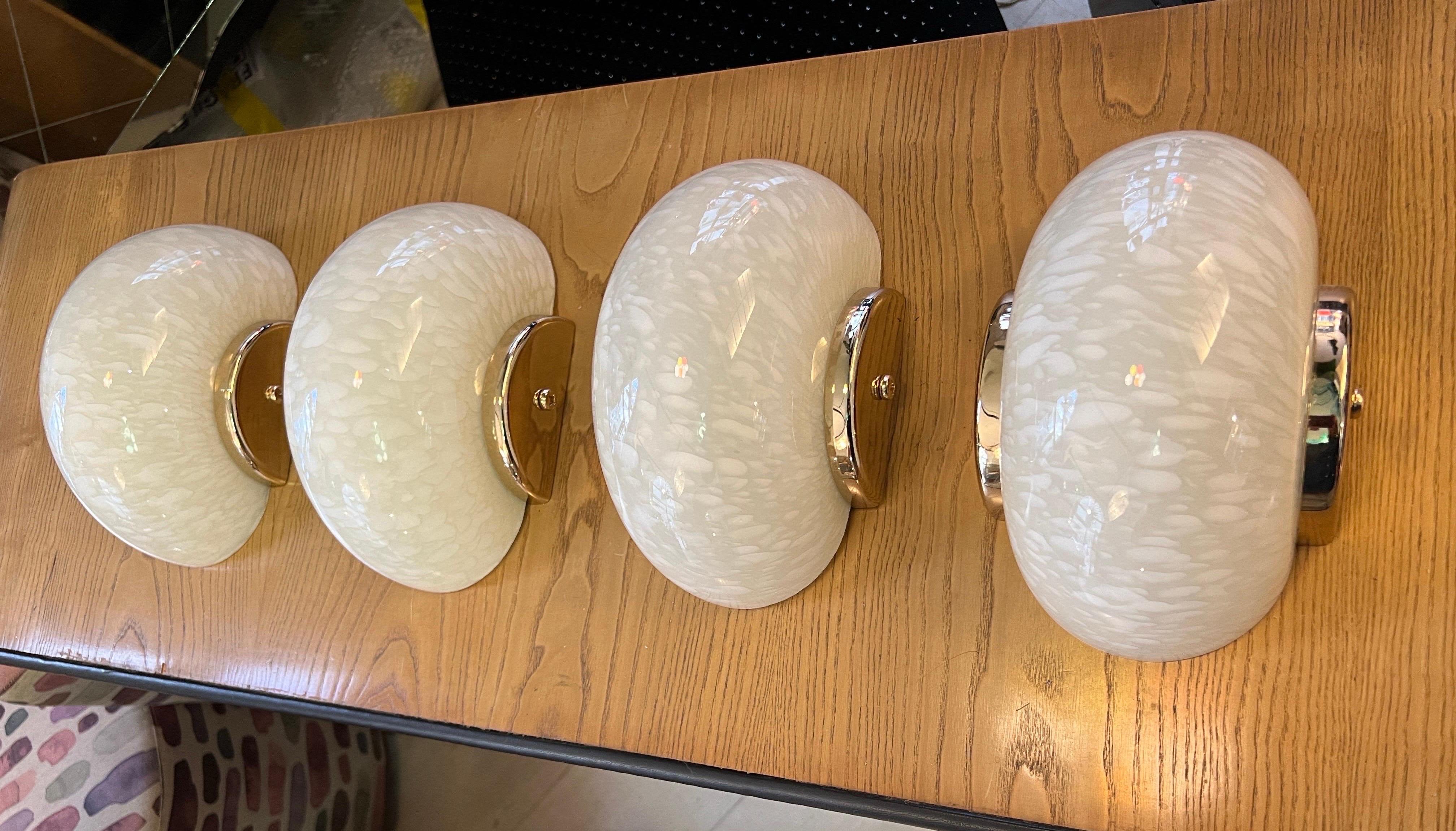 Set of Four Mid-Century Speckled Cream Murano Glass Wall Sconces with brass fittings. The wall lights can be mounted both vertically and horizontally. The Murano Glass is cream color and lightly spotted.
One regular bulb each lamp.
 
