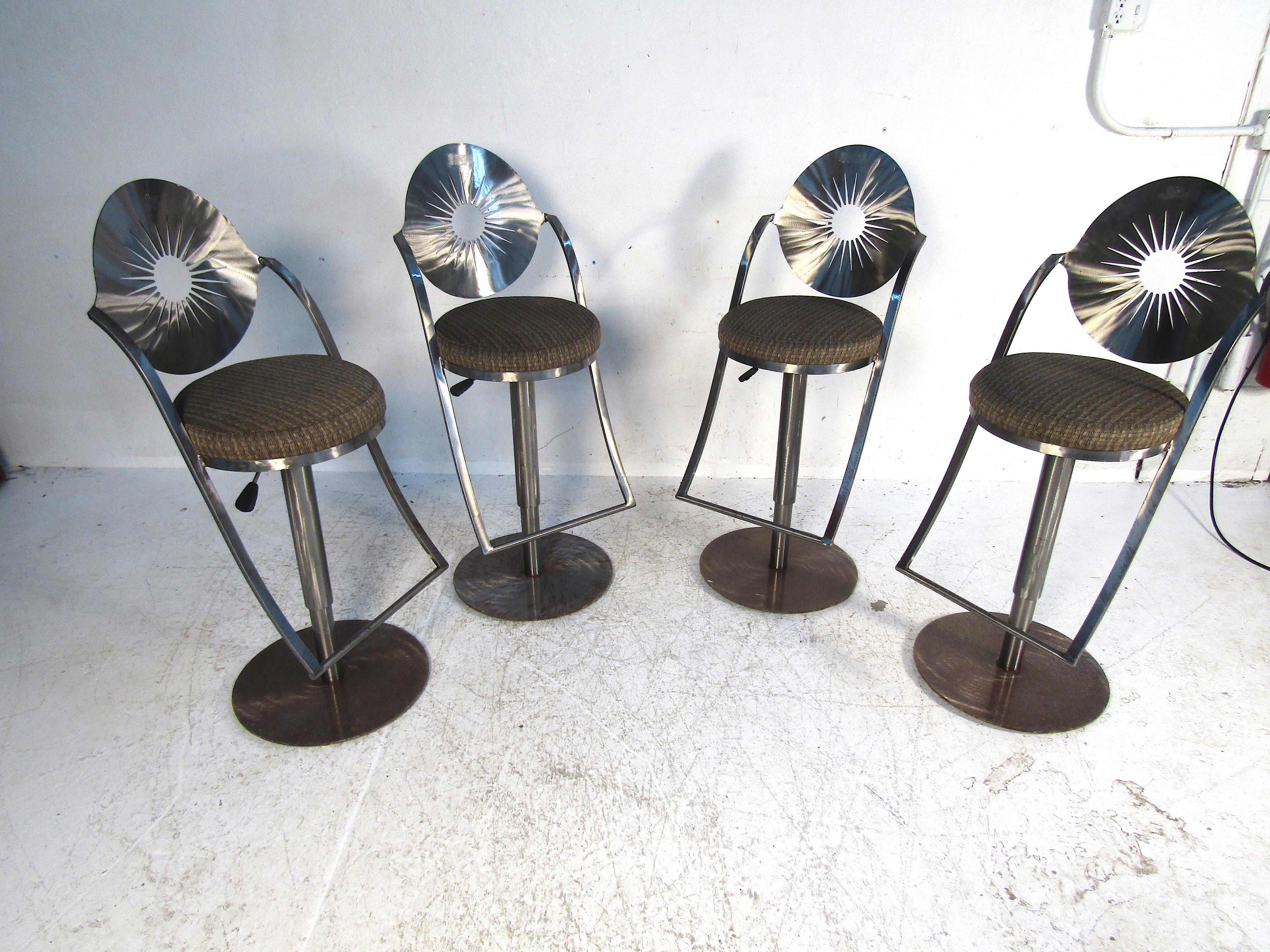 This set of vintage bar stools features heavy brushed steel construction and a plush upholstery base. The top half of the stools is one seamless piece of steel creating a very unique style. This set is perfect for any kitchen or home bar area.