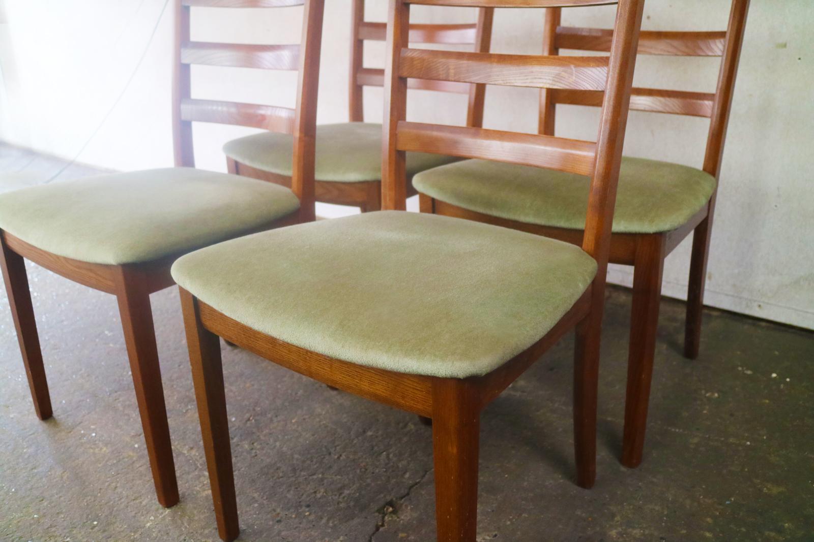 A handsome set of four dining chairs upholstered in the original light green velour fabric.