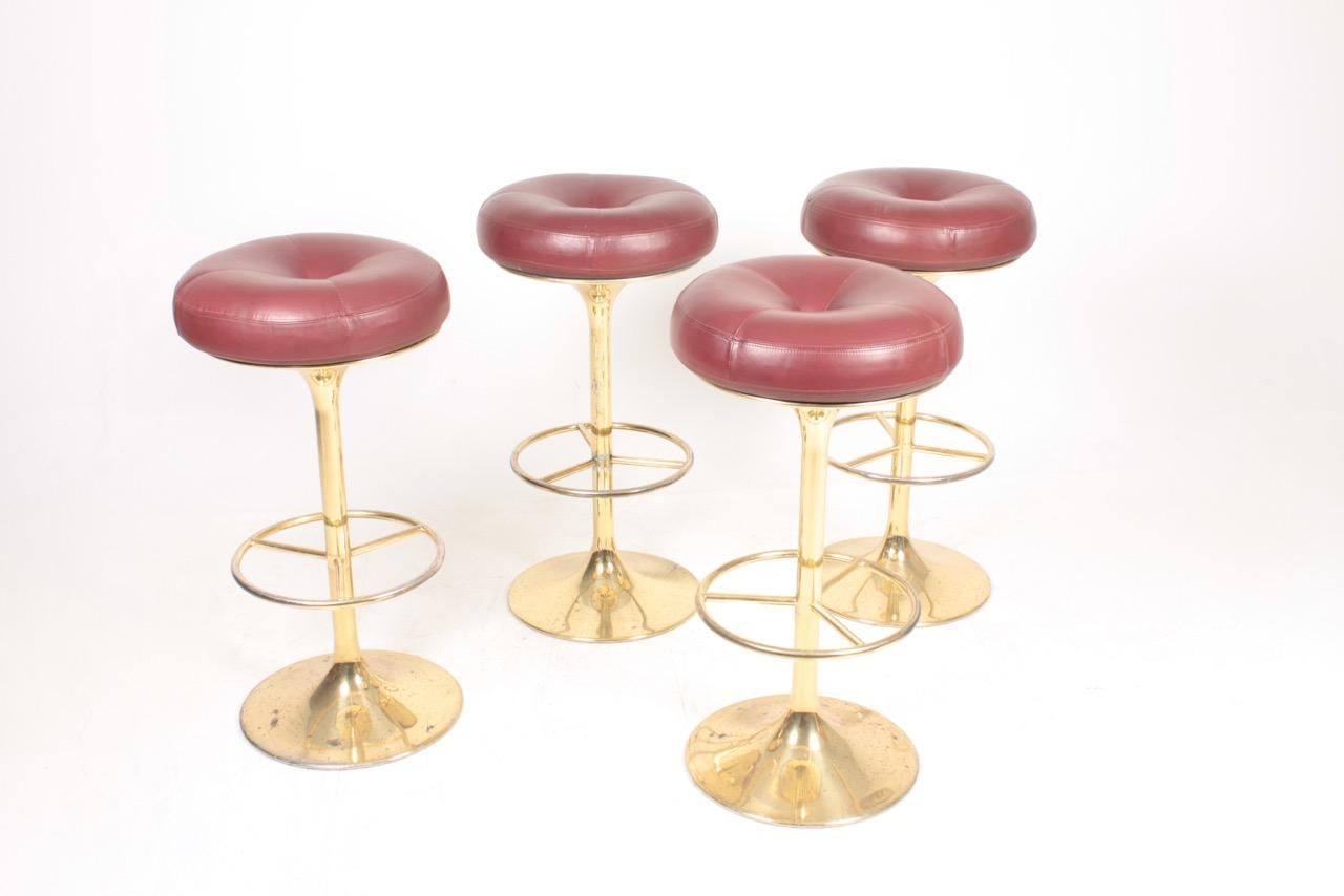 Set of four of high stools in brass with patinated leather seats. Designed by and made by Börge Johansson design in Markaryd, Sweden. Ideal for the kitchen or in a bar.